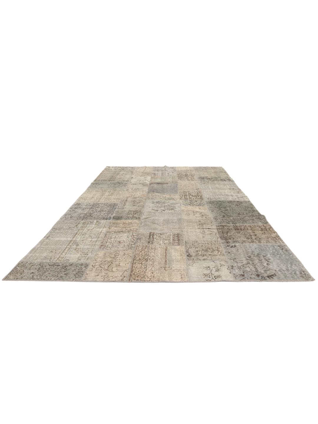 Een uniek patchwork tapijt uit het Midden-Oosten met een neutraal kleurenpalet van beige en grijstinten.