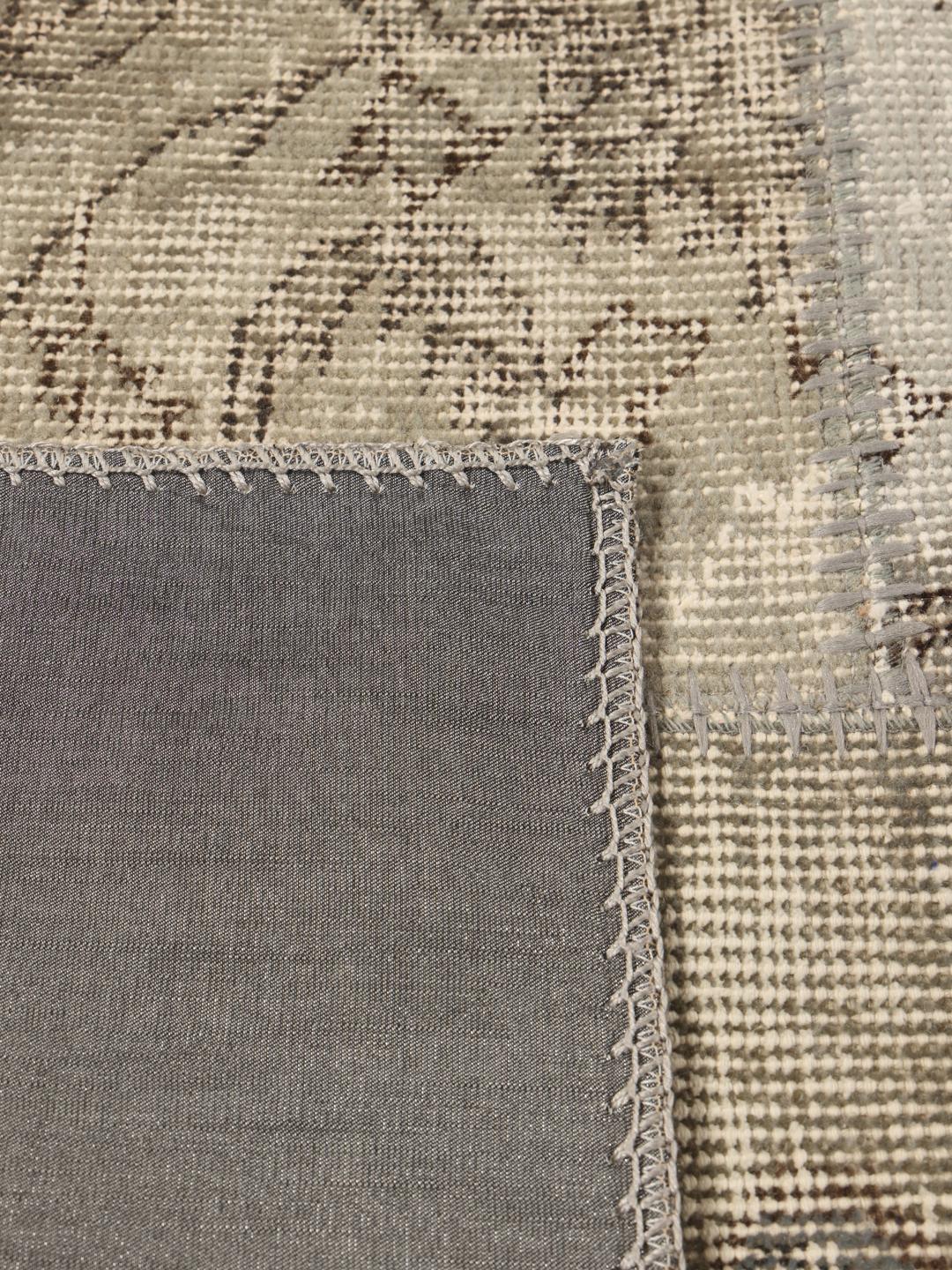 Een uniek patchwork tapijt uit het Midden-Oosten met een neutraal kleurenpalet van beige en grijstinten.