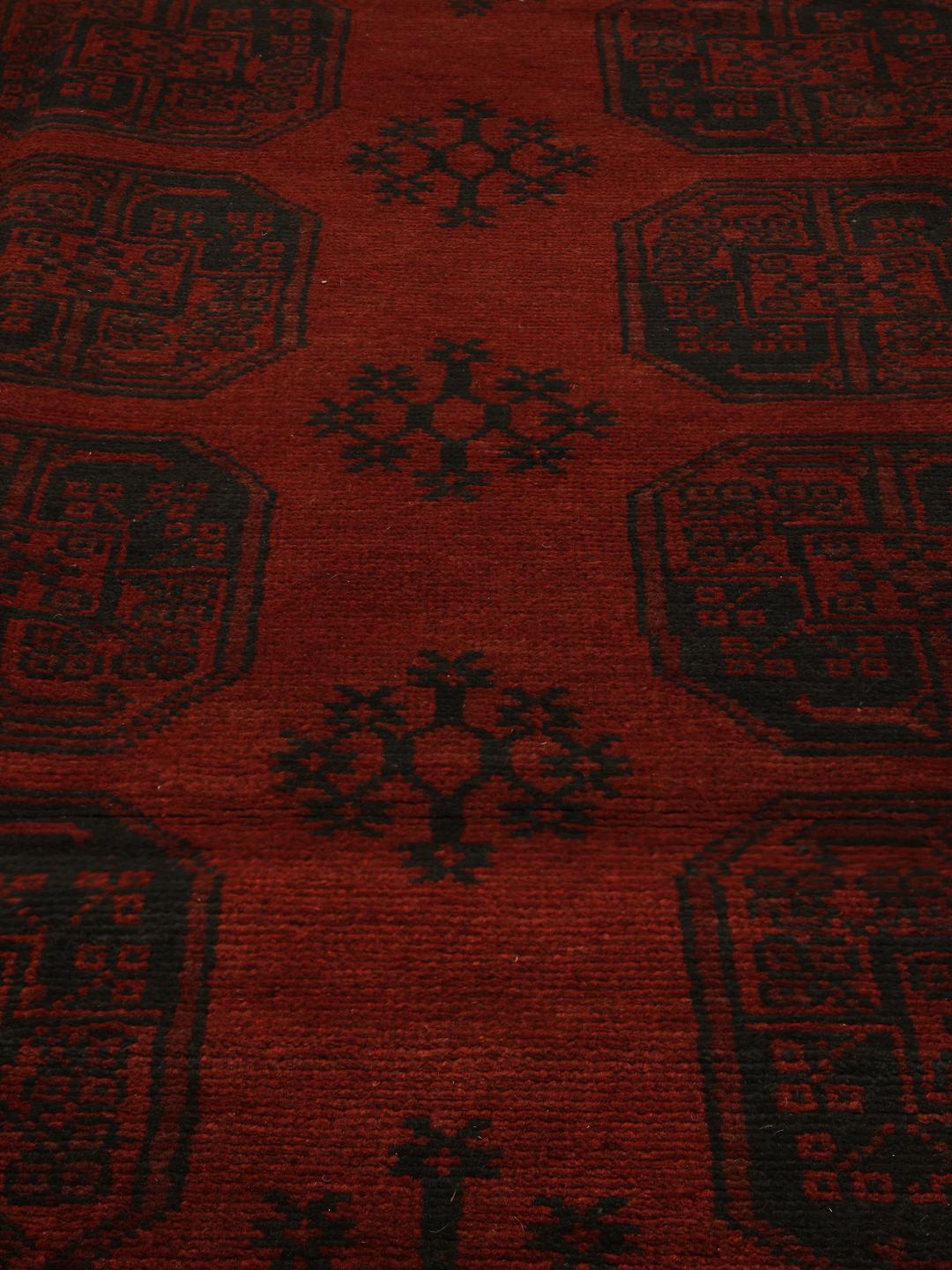 Handgeknoopt Afghan Fine-tapijt met complexe tribale motieven in donkerrood en zwart.