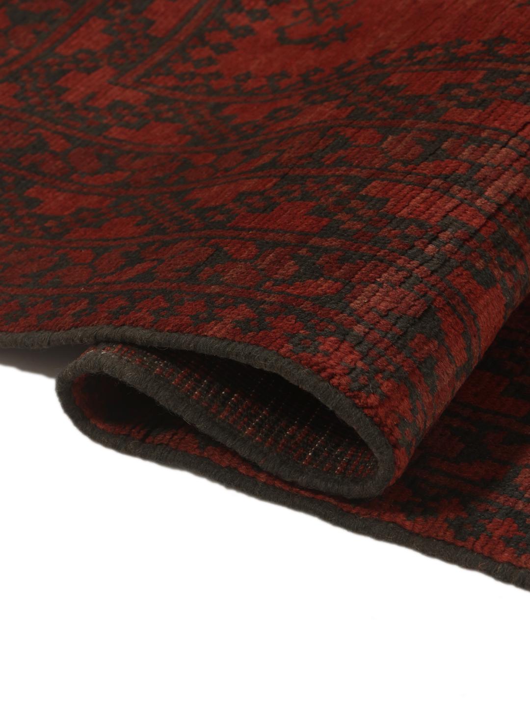 Handgeknoopt Afghan Fine-tapijt met complexe tribale motieven in donkerrood en zwart.