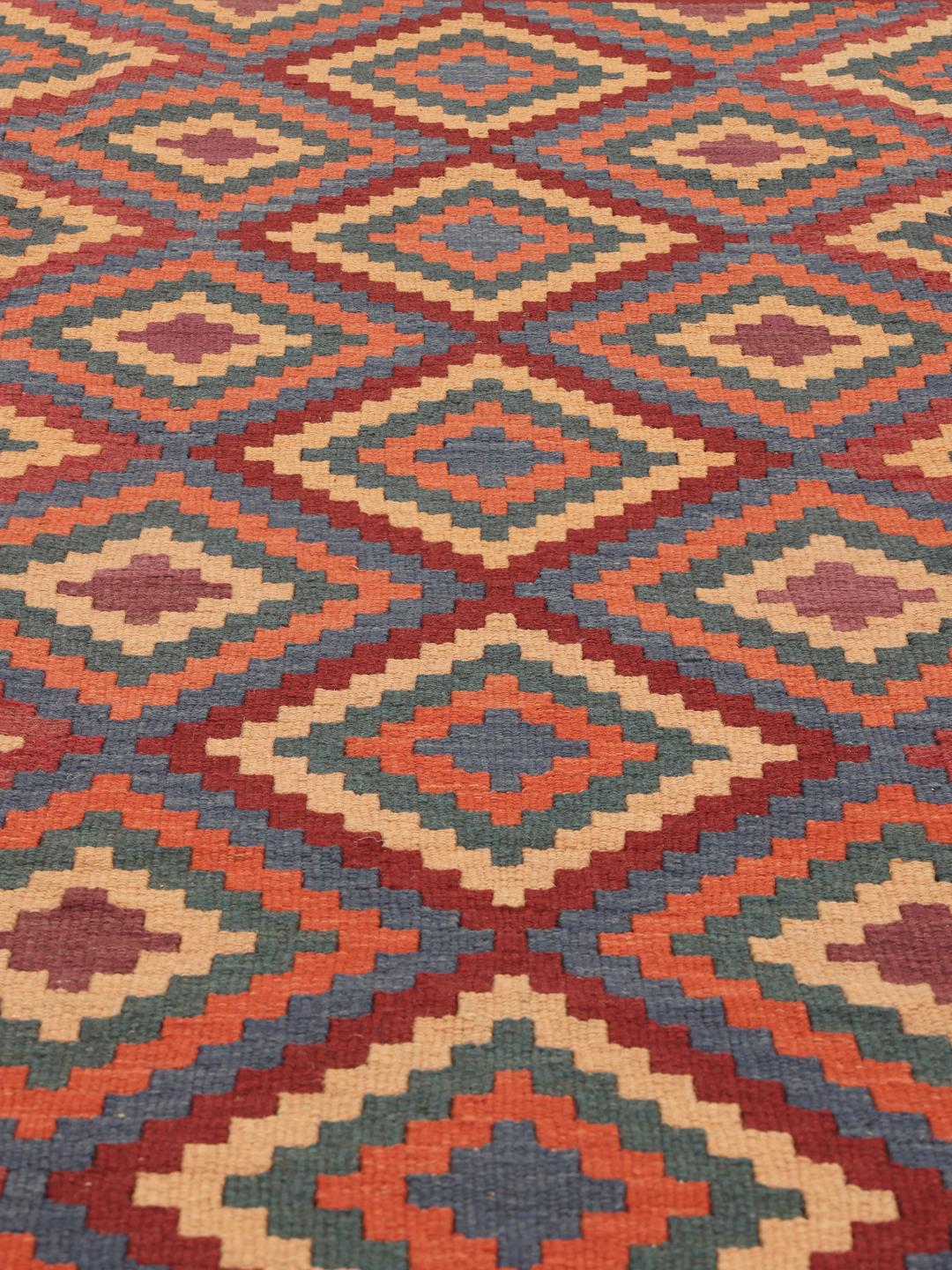 Handgeweven Kelim Ghashghai tapijt met een levendig geometrisch patroon in rood-, blauw- en oranjetinten.