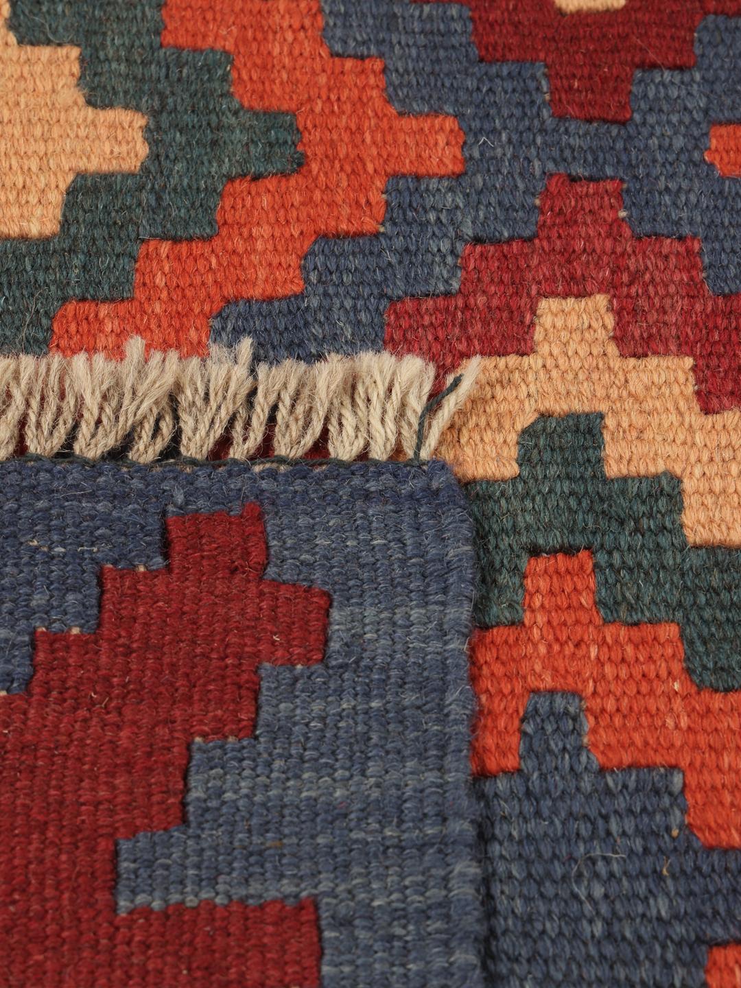Handgeweven Kelim Ghashghai tapijt met een levendig geometrisch patroon in rood-, blauw- en oranjetinten.