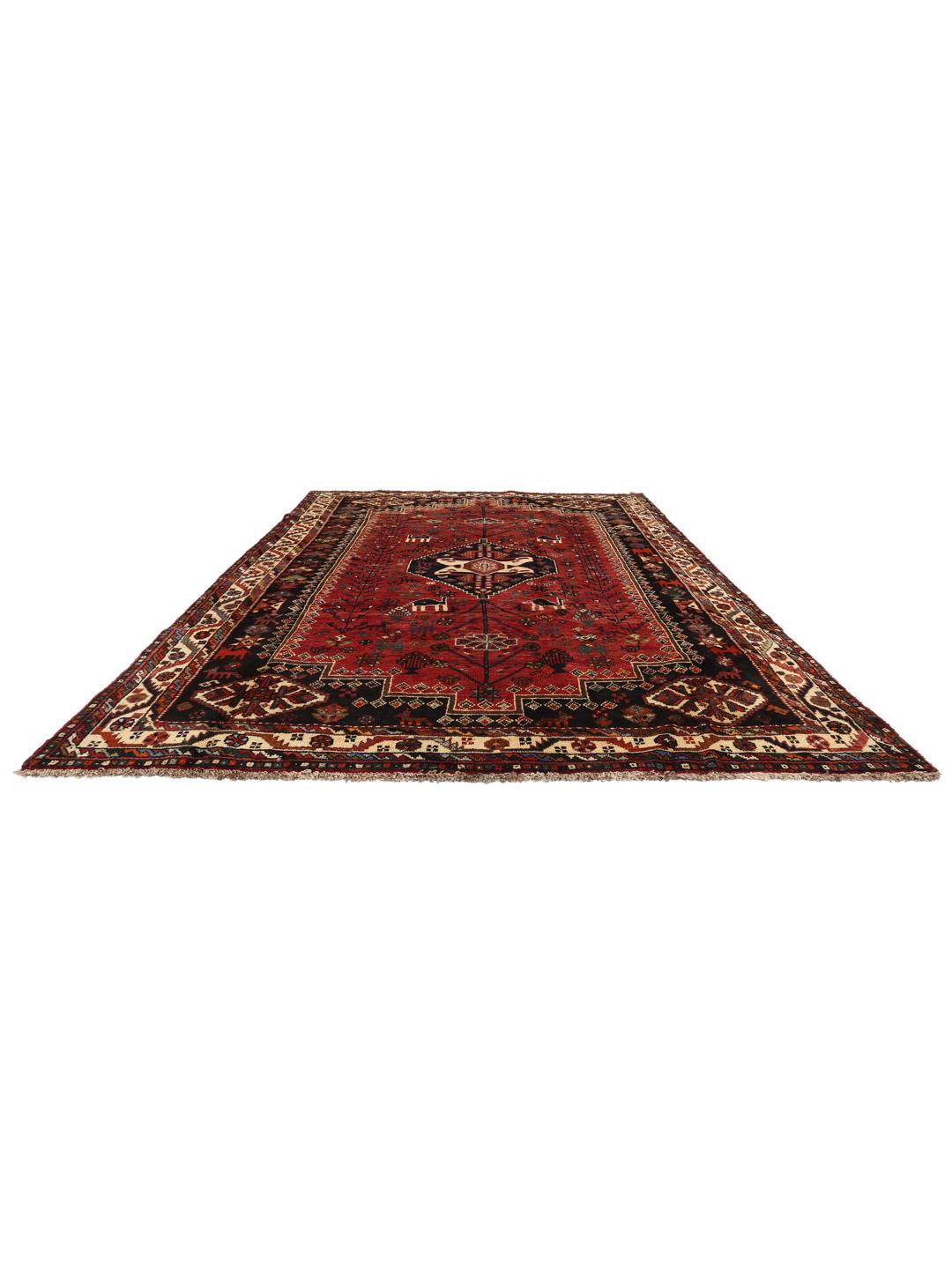 Hand-woven Shiraz rug from the Middle East featuring a vibrant red and black palette with tribal motifs