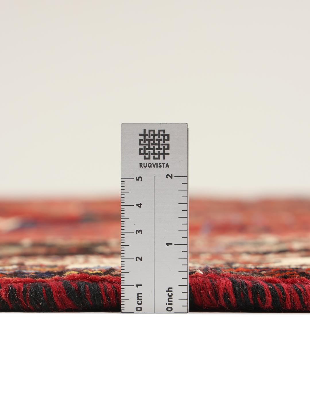 Hand-woven Shiraz rug from the Middle East featuring a vibrant red and black palette with tribal motifs