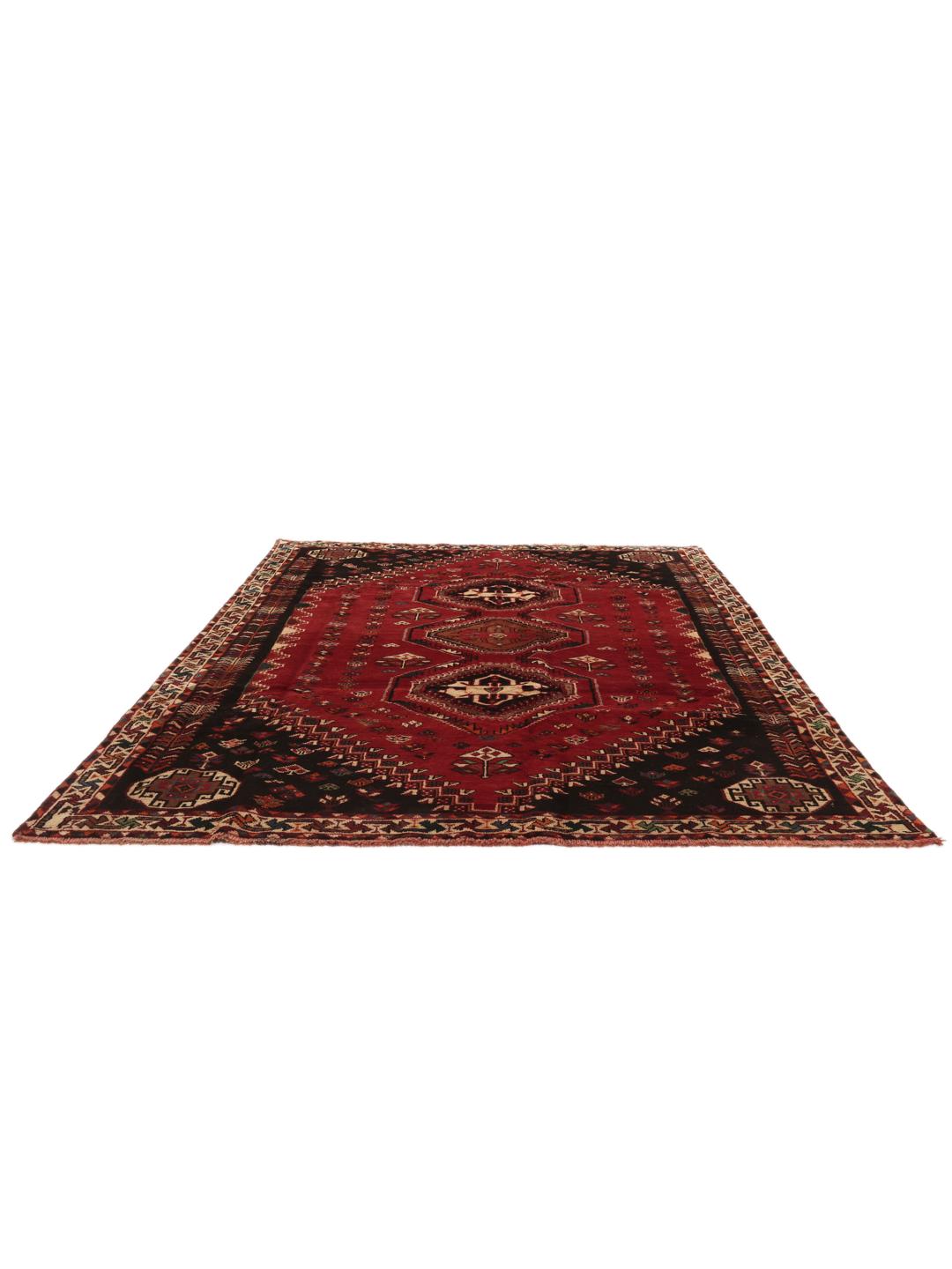 Hand-woven Shiraz rug from the Middle East featuring a vibrant red field and tribal motifs