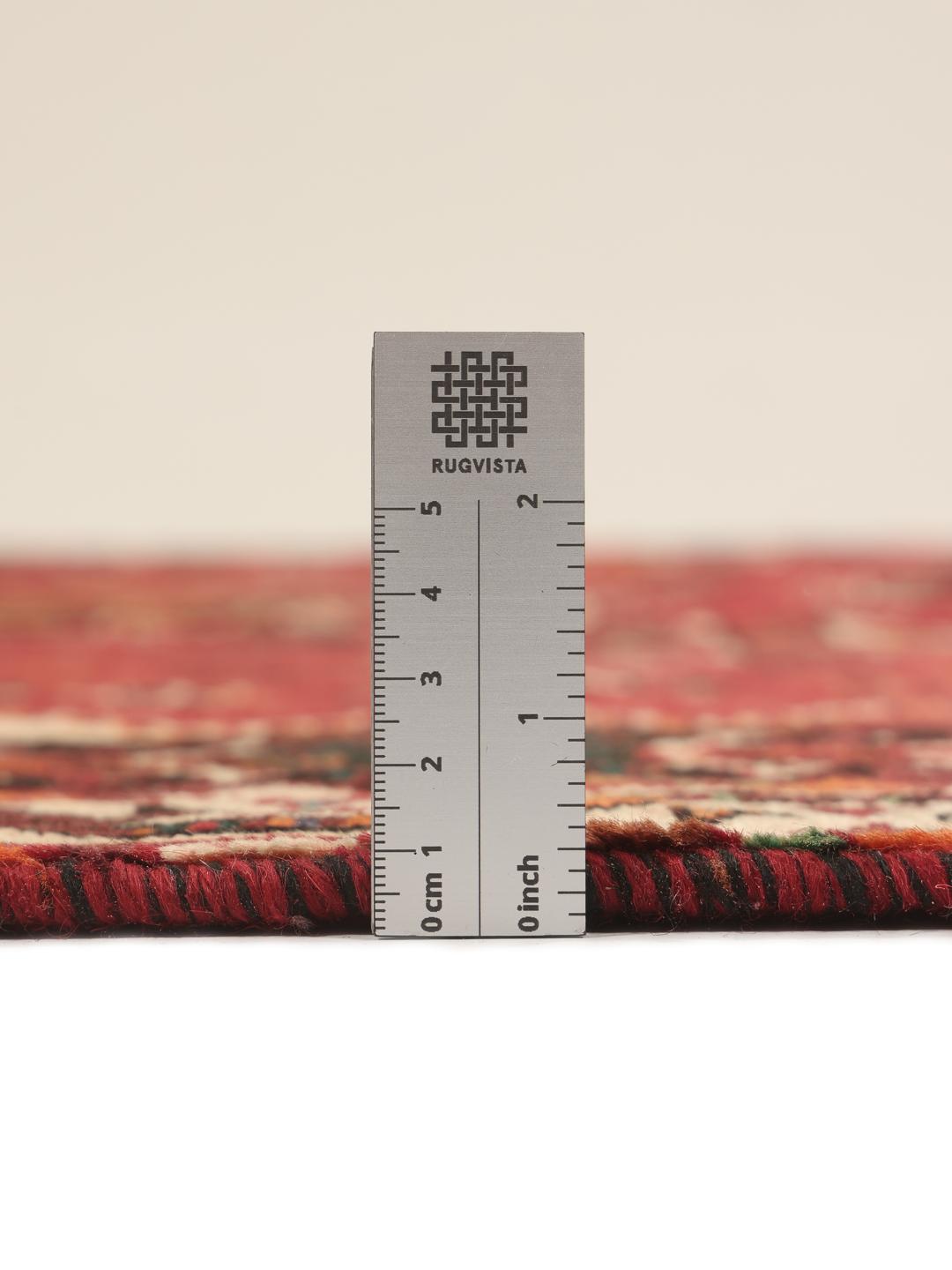 Hand-woven Shiraz rug from the Middle East featuring a vibrant red field and tribal motifs