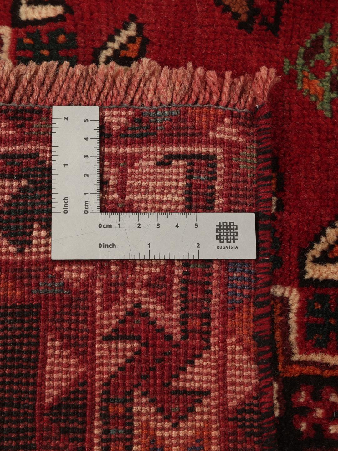 Hand-woven Shiraz rug from the Middle East featuring a vibrant red field and tribal motifs