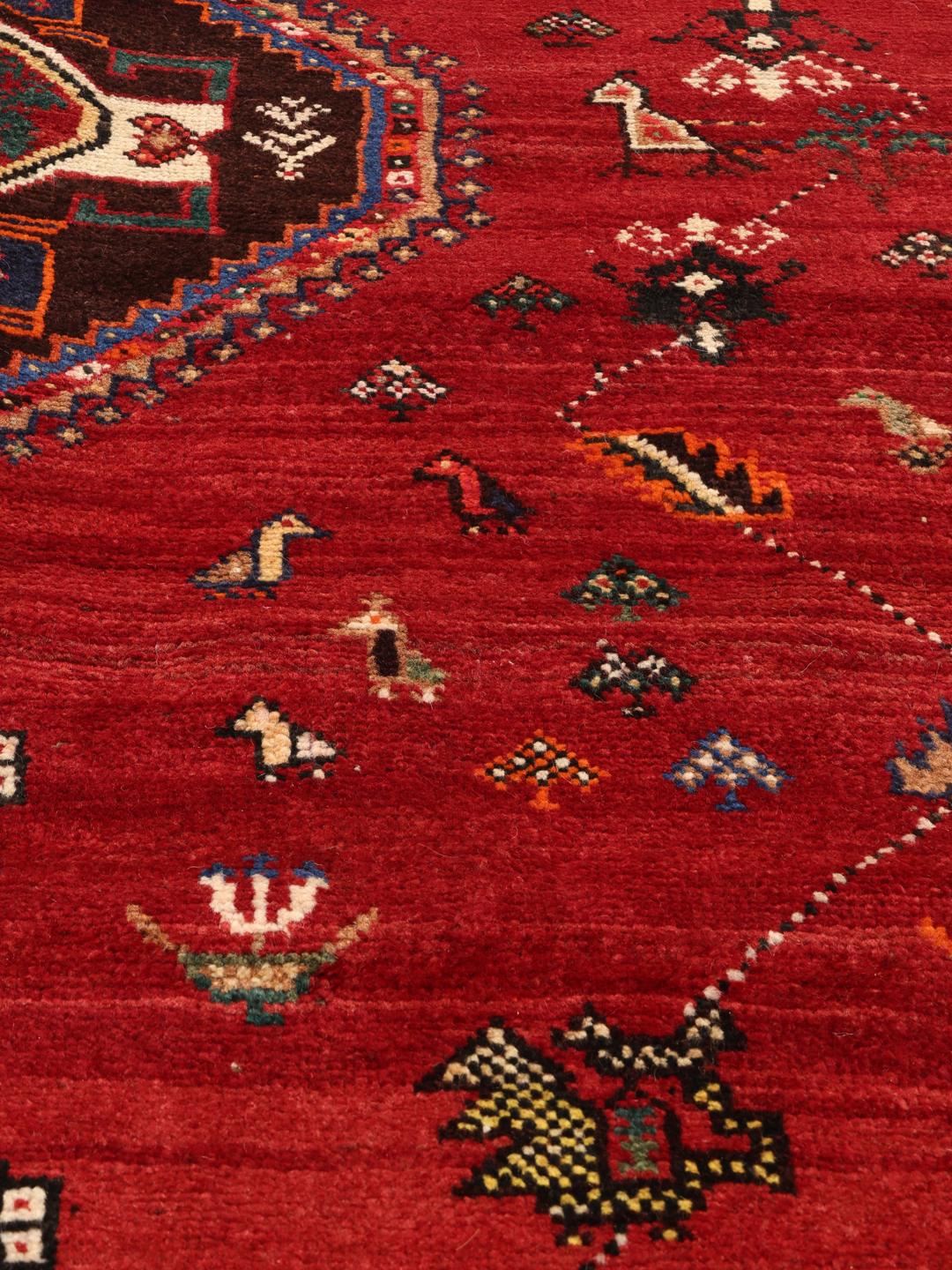 Hand-knotted Qashqai rug with a red field and geometric tribal patterns