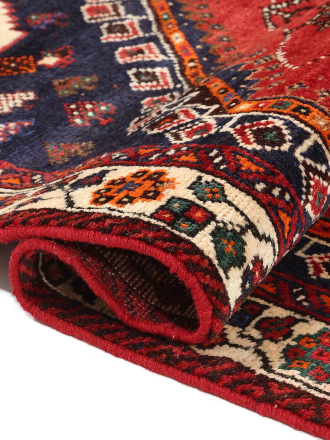 Hand-knotted Qashqai rug with a red field and geometric tribal patterns