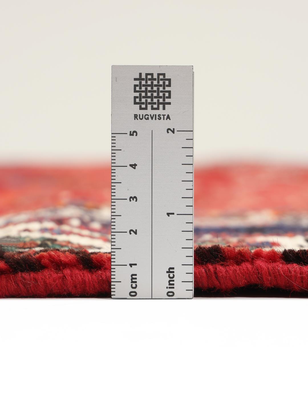 Hand-knotted Qashqai rug with a red field and geometric tribal patterns