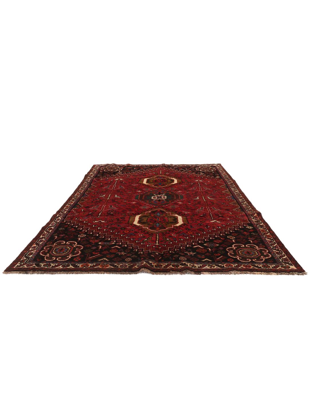 Hand-woven Shiraz rug from the Middle East featuring a red and black tribal pattern.