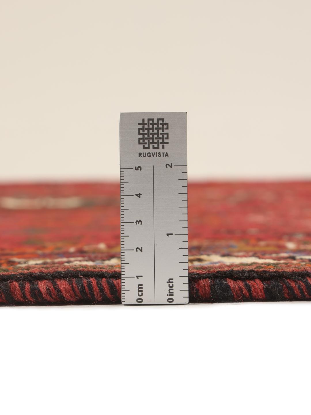 Hand-woven Shiraz rug from the Middle East featuring a red and black tribal pattern.