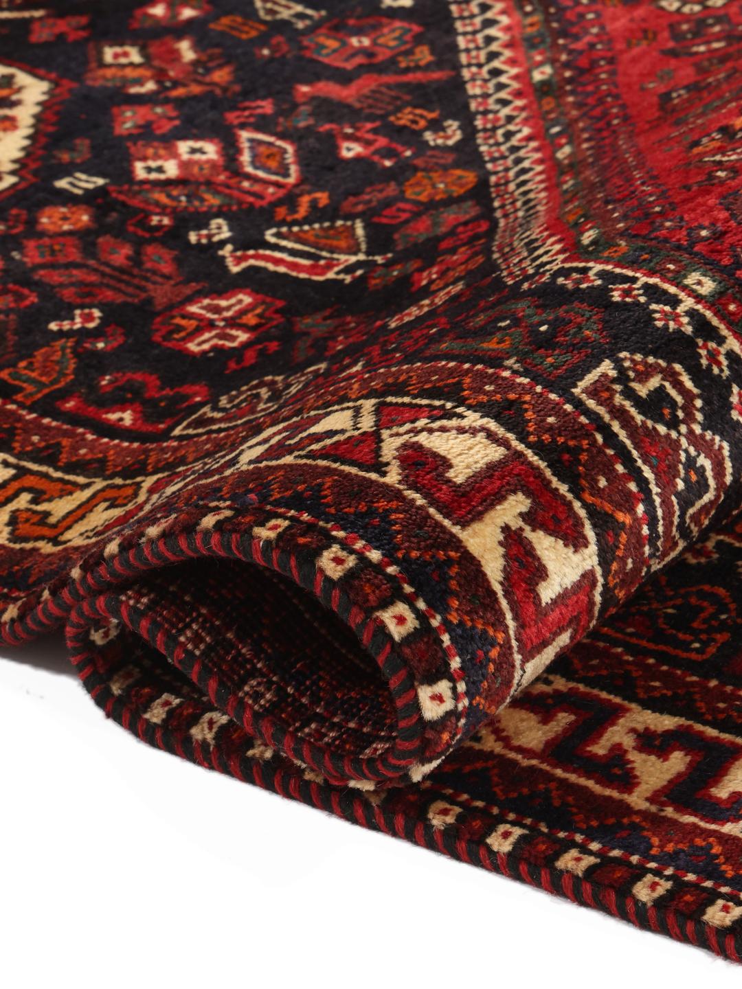 Hand-knotted Middle Eastern tribal rug with red and black geometric patterns
