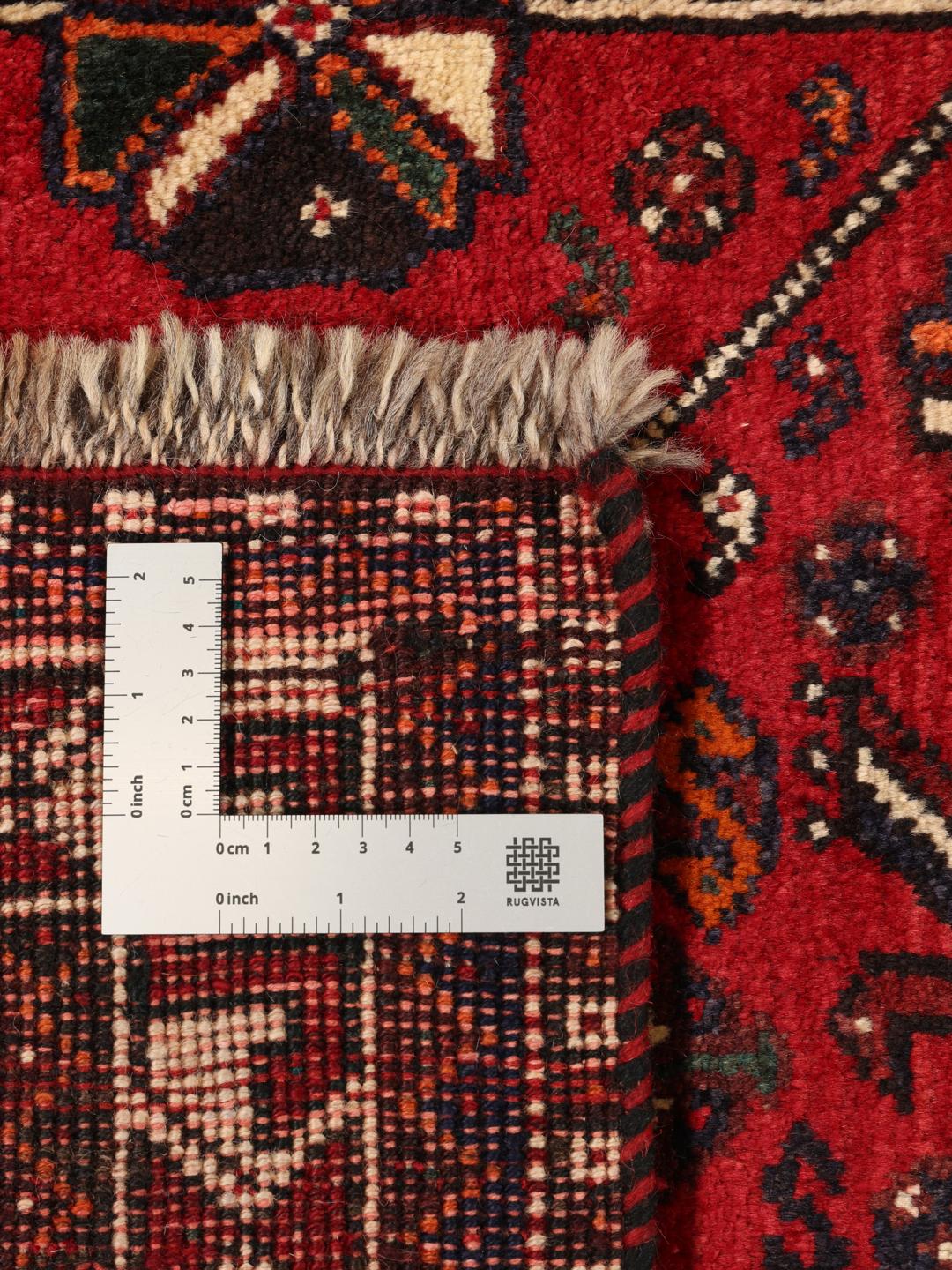 Hand-knotted Middle Eastern tribal rug with red and black geometric patterns