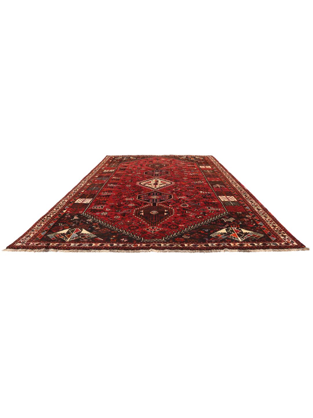 A beautiful hand-knotted Qashqai rug from the Middle East with a red field and traditional patterns.