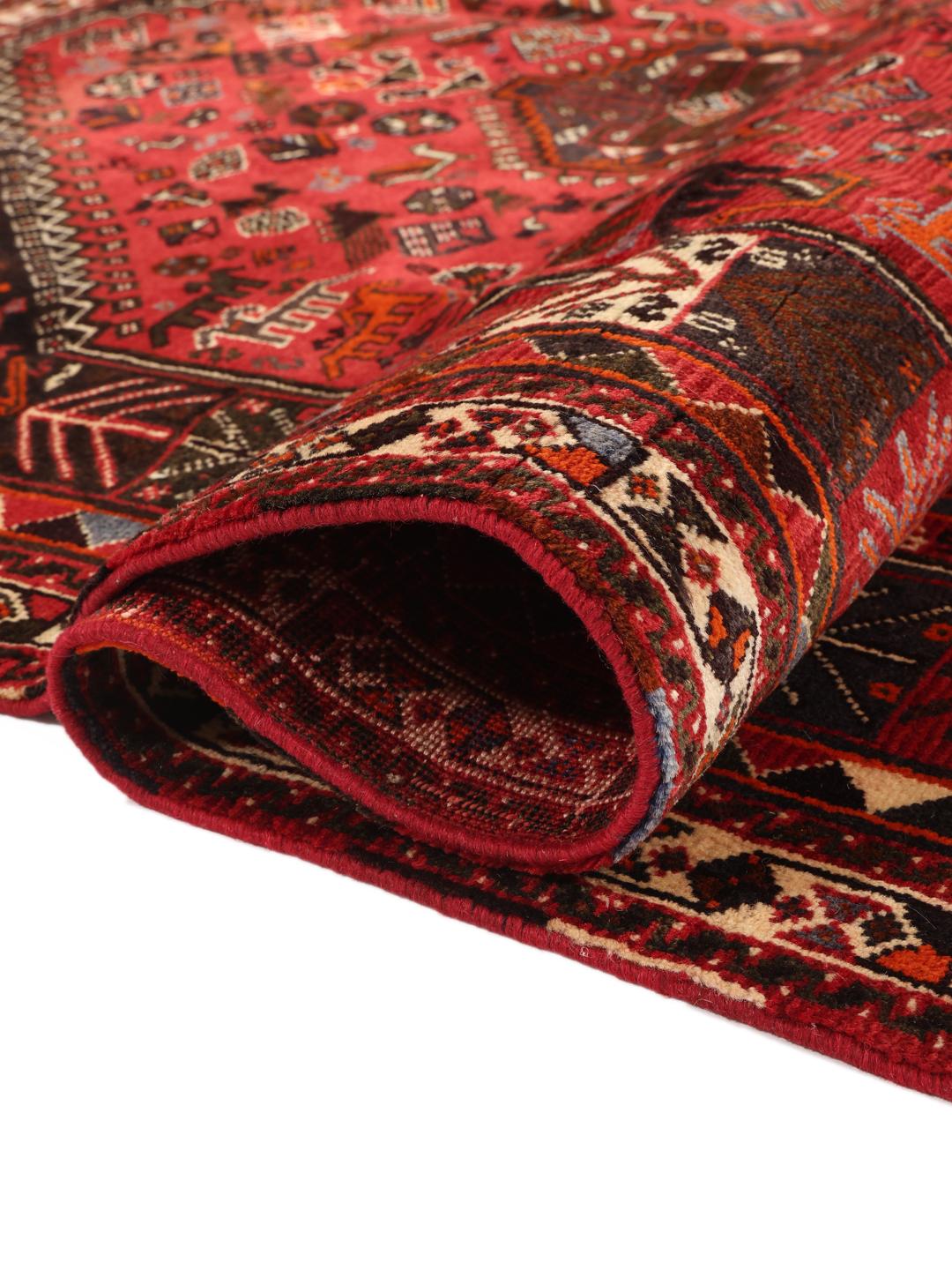 A beautiful hand-knotted Qashqai rug from the Middle East with a red field and traditional patterns.