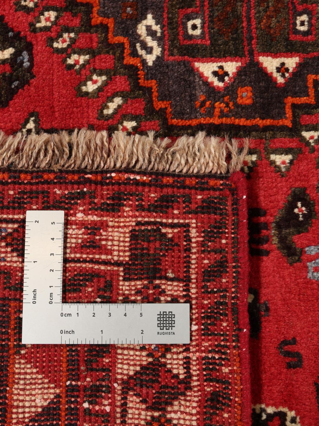A beautiful hand-knotted Qashqai rug from the Middle East with a red field and traditional patterns.