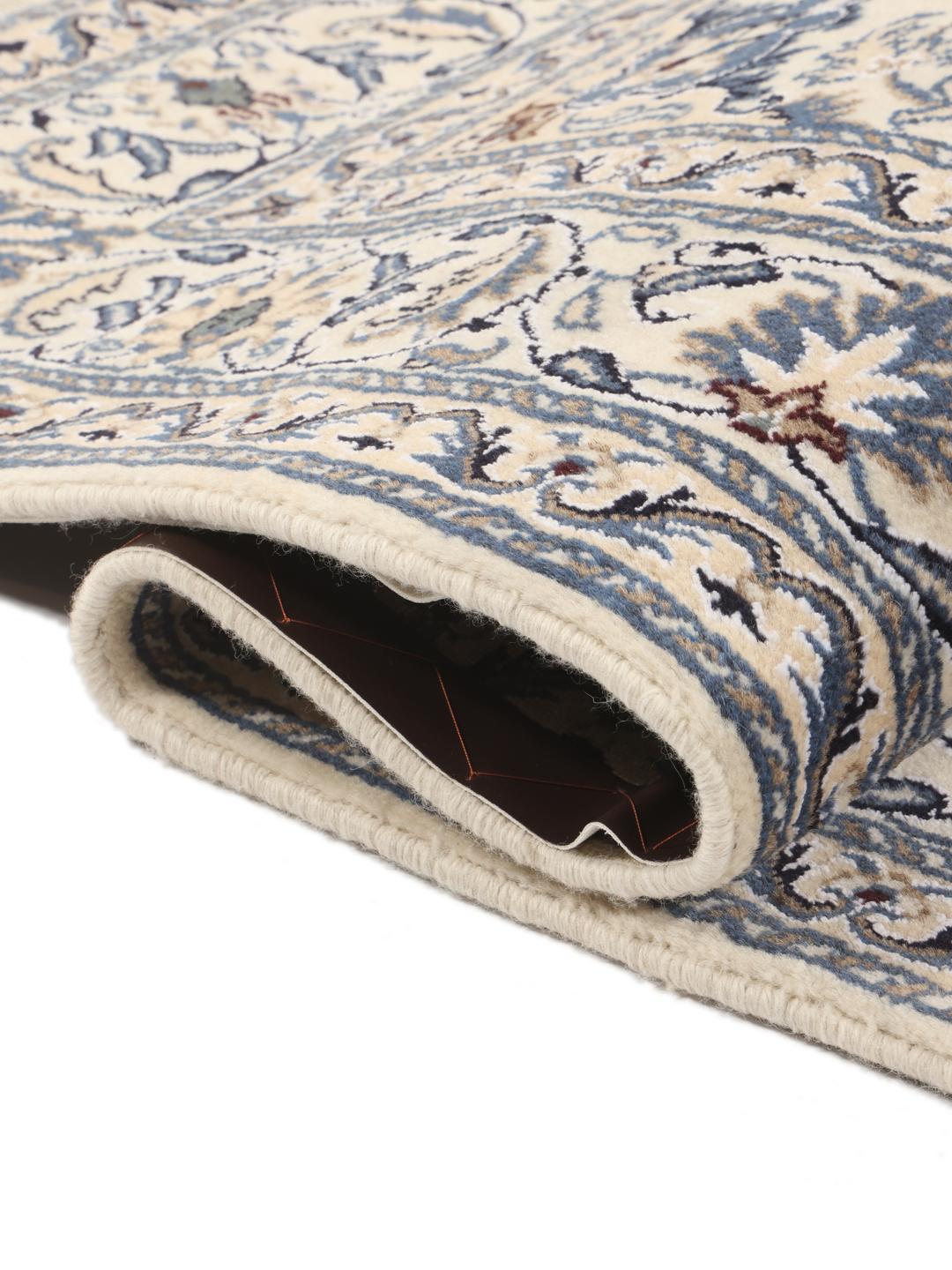 A hand-knotted Nain rug from the Middle East featuring a blue and beige floral design.