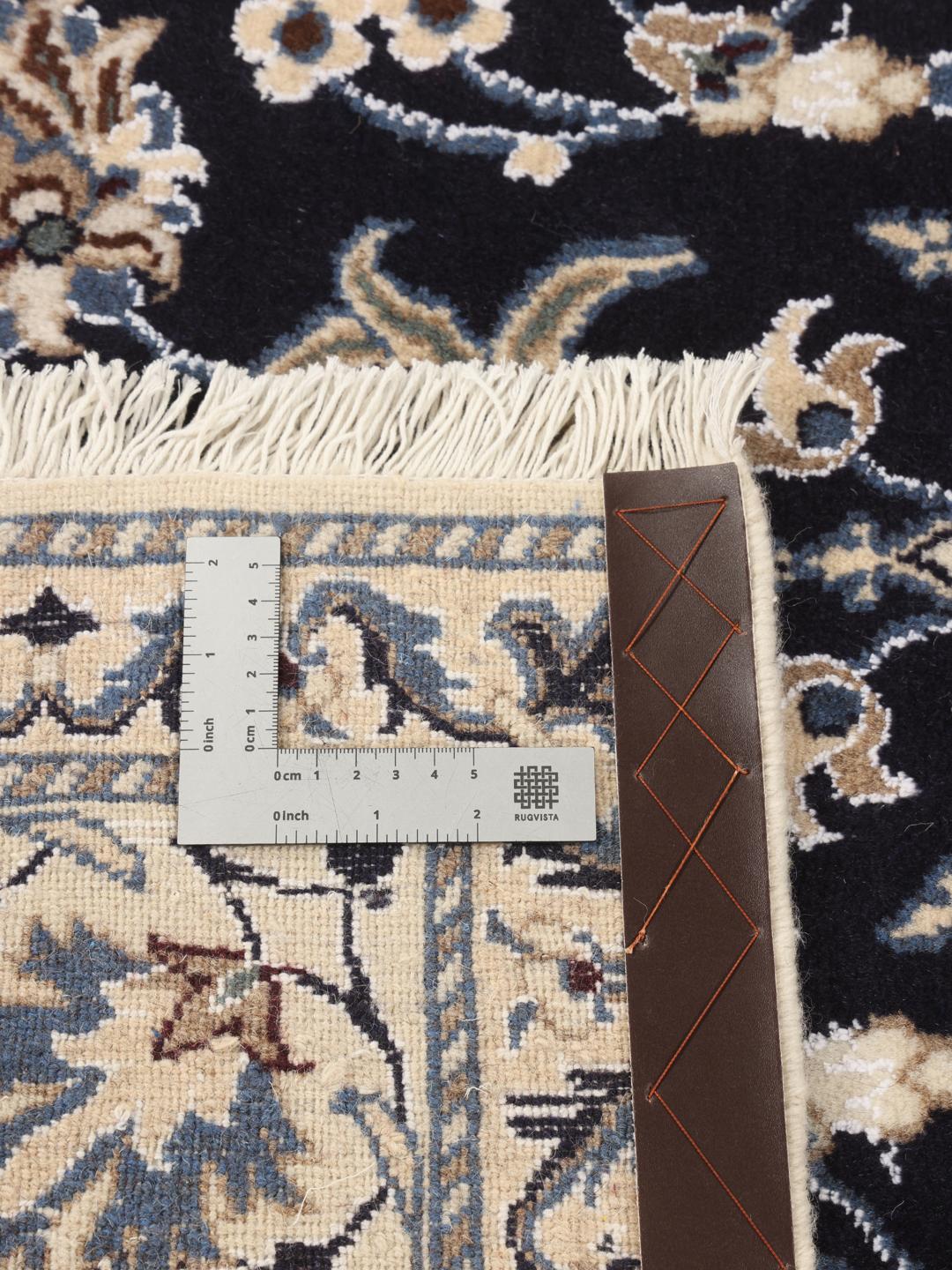 A hand-knotted Nain rug from the Middle East featuring a blue and beige floral design.