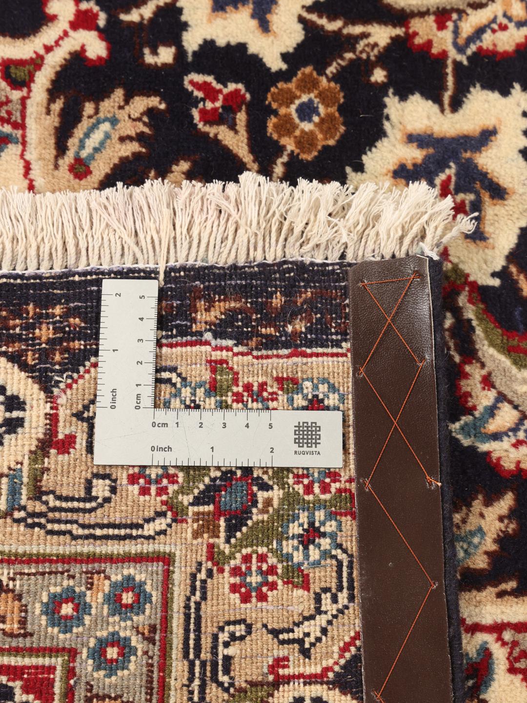Et detaljeret, håndknyttet Kashmar-tæppe fra Mellemøsten med et indviklet mørkerødt og mørkeblåt design.