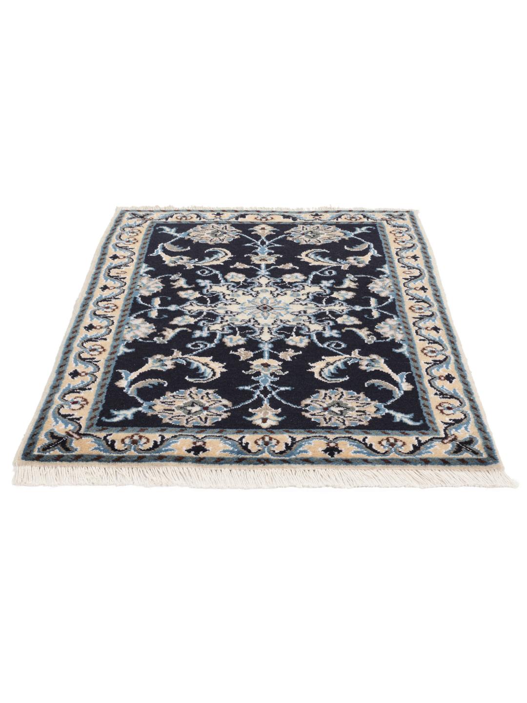 A hand-knotted Nain rug from the Middle East with a deep blue field and floral motifs.