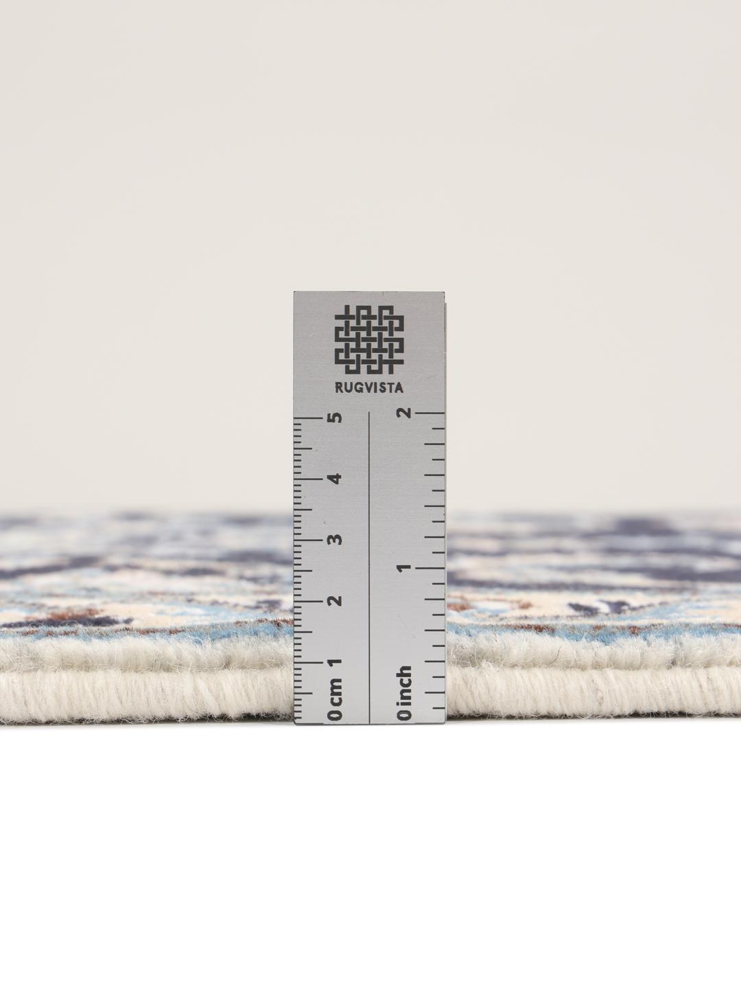 A hand-knotted Nain rug from the Middle East with a deep blue field and floral motifs.