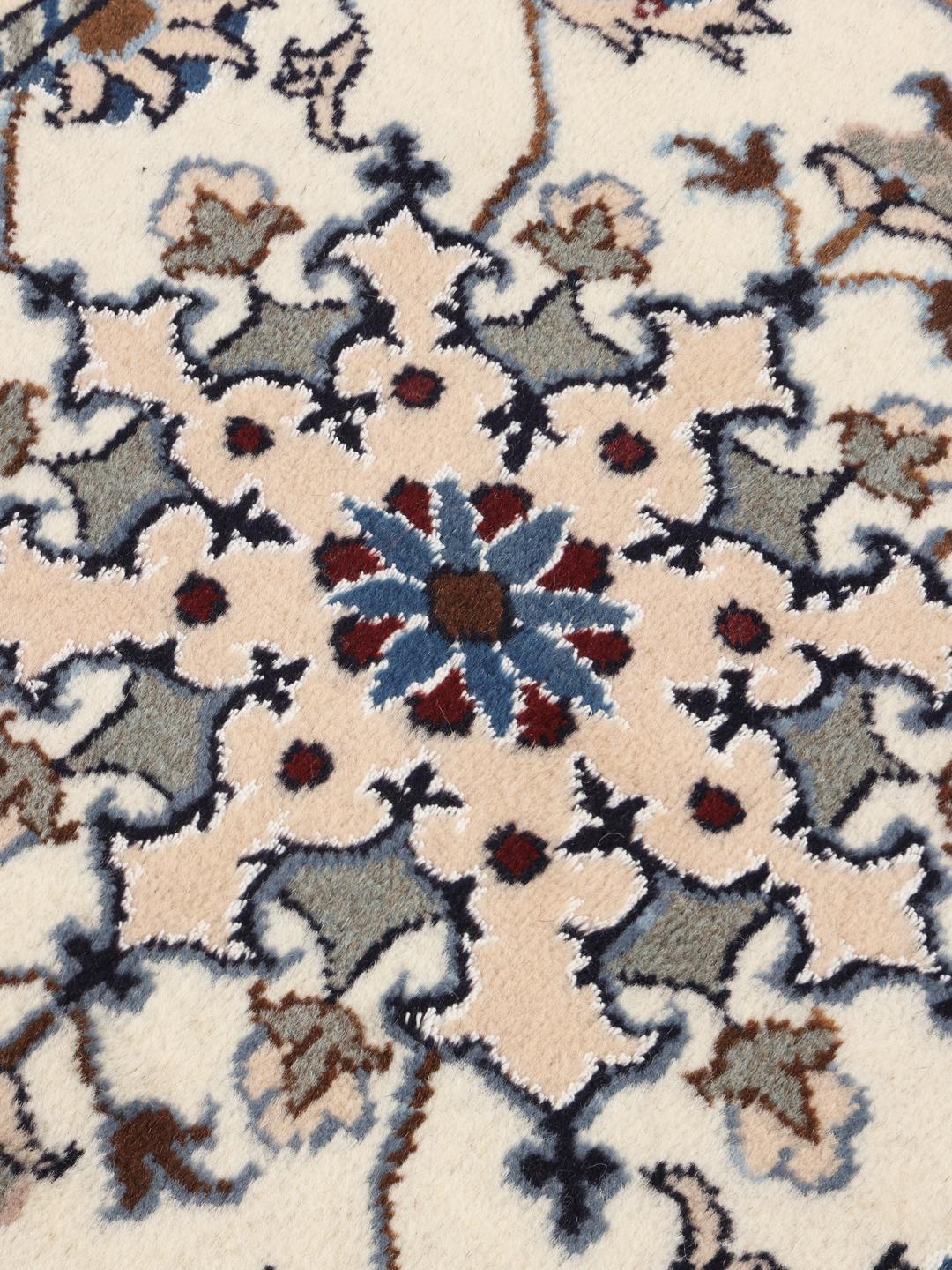 Hand-knotted Nain rug from the Middle East in beige, blue, and red tones.