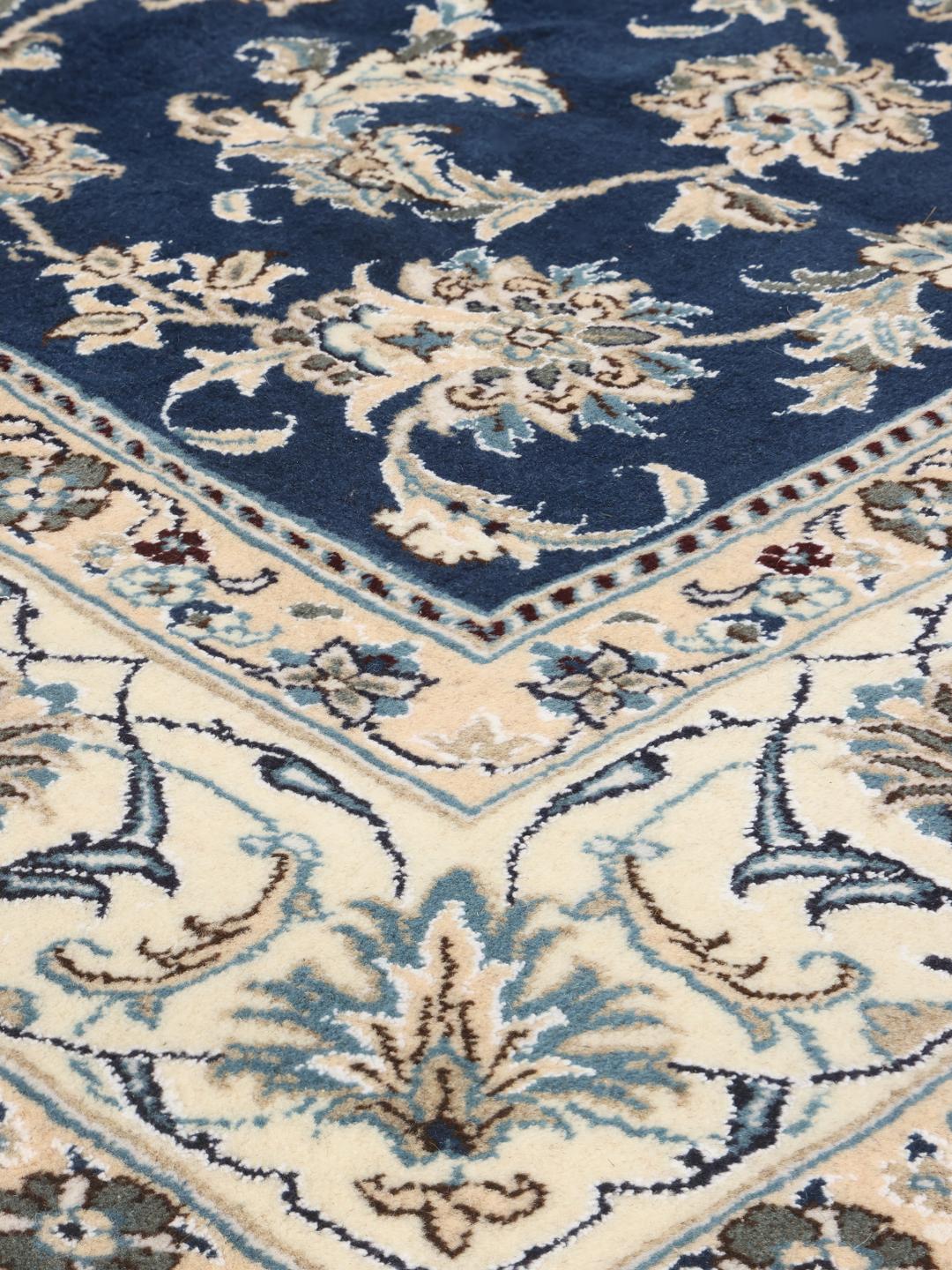 Hand-knotted Nain rug from the Middle East with a deep blue floral pattern