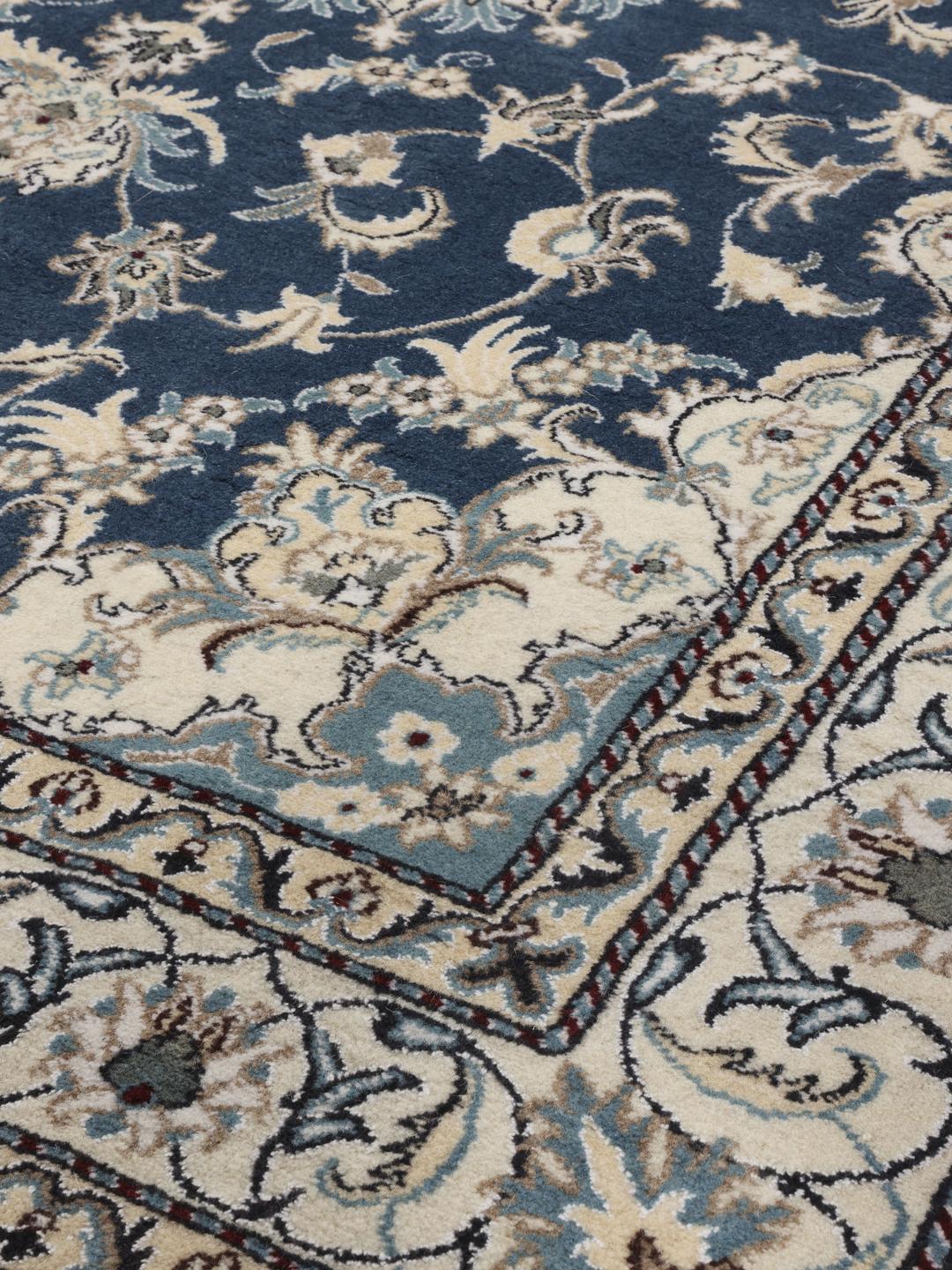 Hand-knotted Nain rug from the Middle East featuring a blue field with floral patterns.