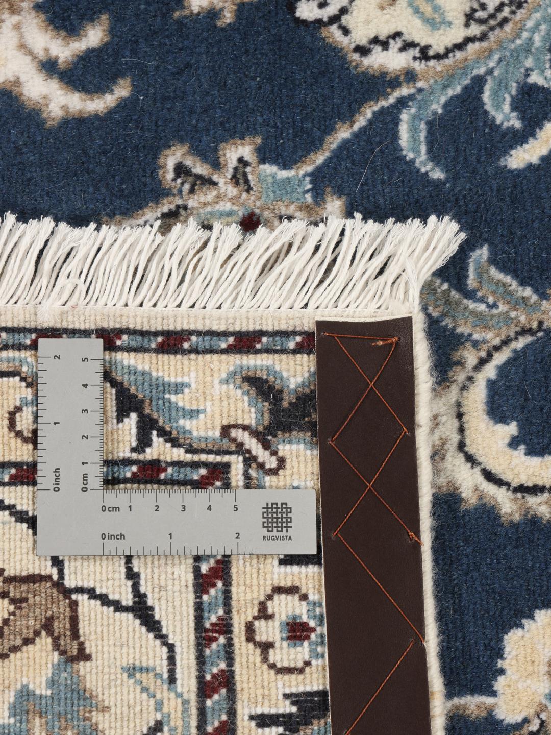 Hand-knotted Nain rug from the Middle East featuring a blue field with floral patterns.