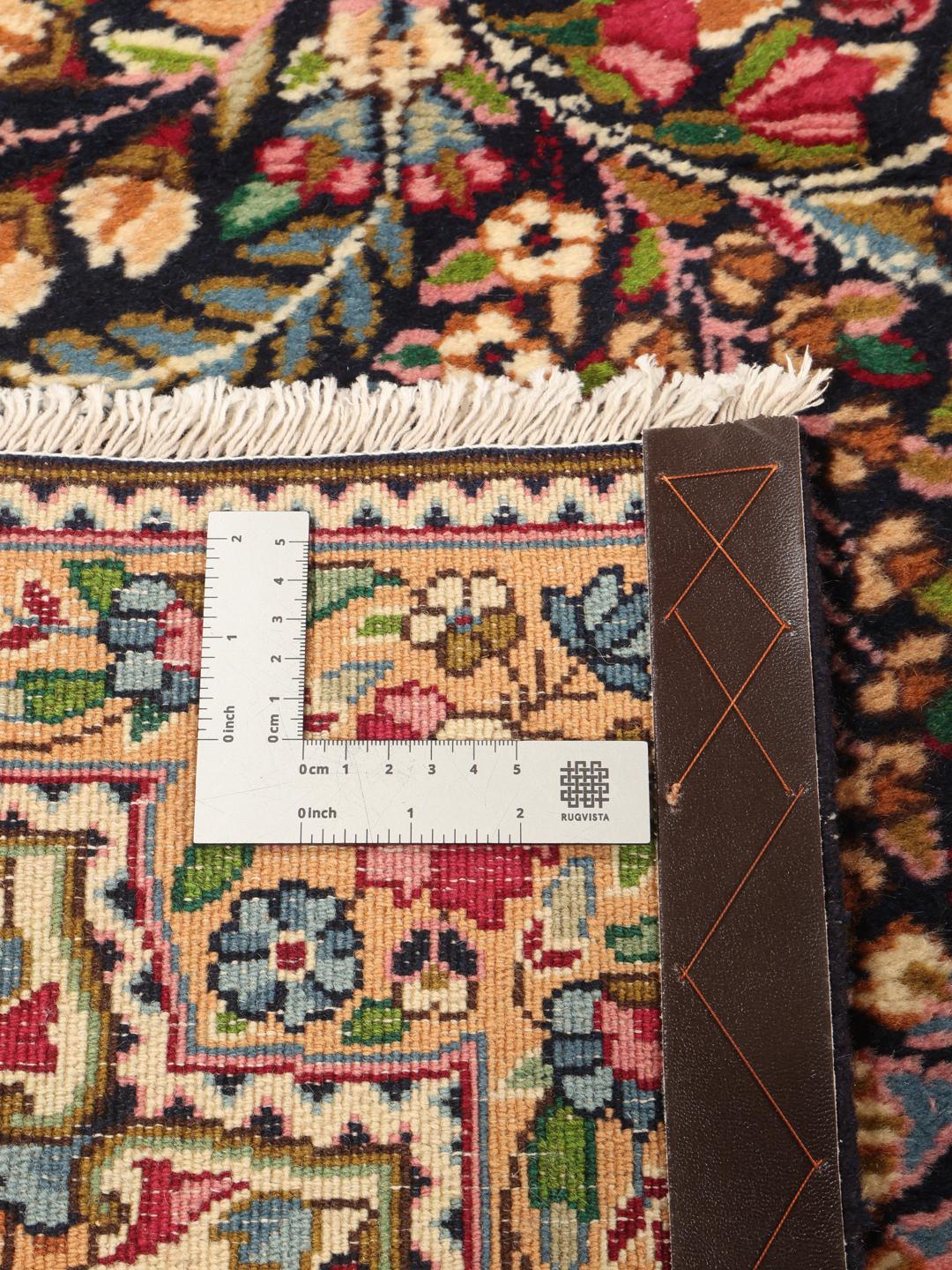A large, rectangular Kerman rug from the Middle East featuring a complex red and dark red floral medallion pattern.