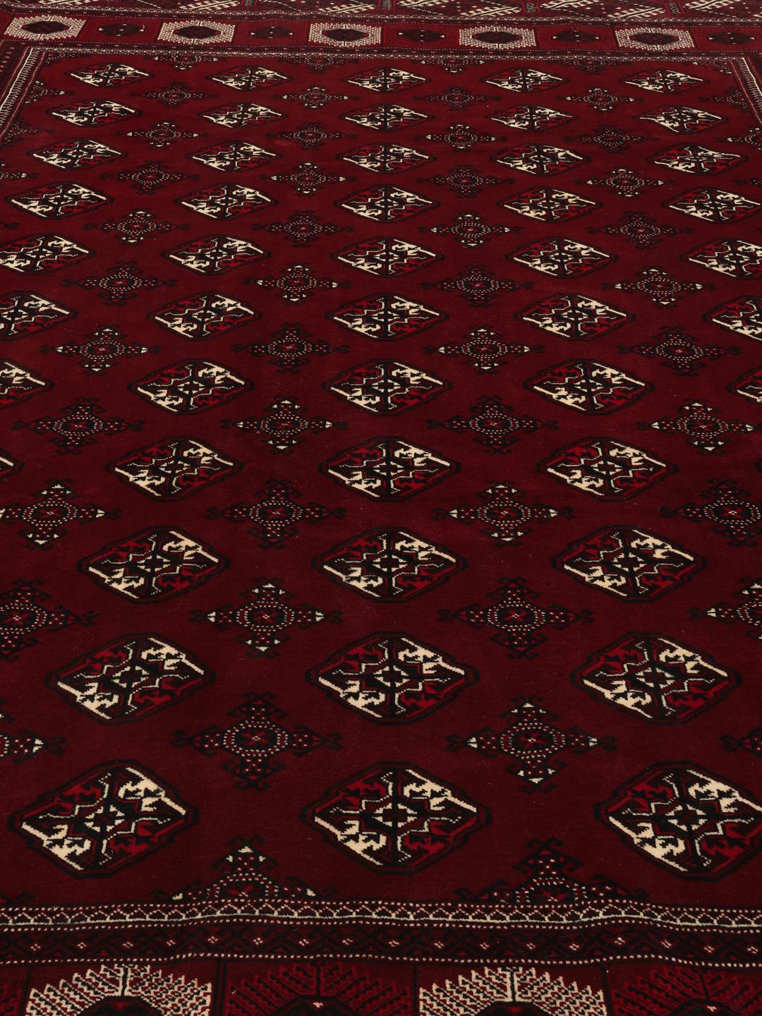 A hand-knotted Turkaman rug from the Middle East in deep red featuring traditional geometric motifs.