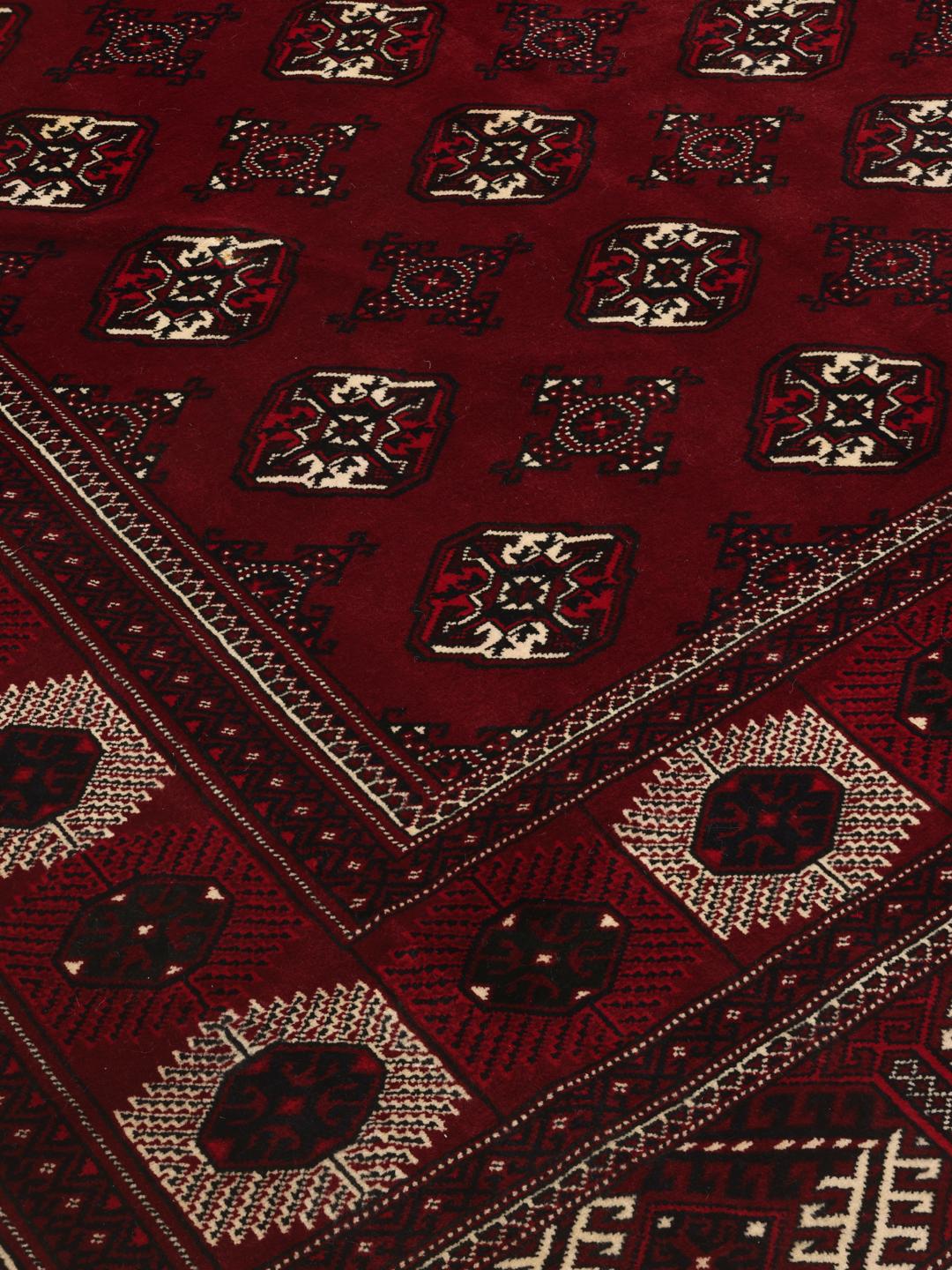 A hand-knotted Turkaman rug from the Middle East in deep red featuring traditional geometric motifs.