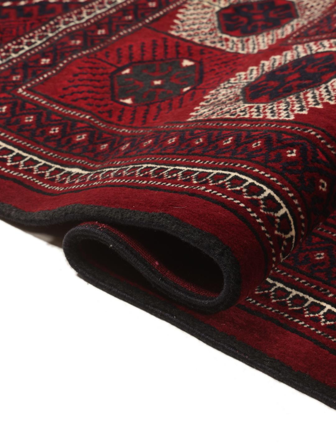 A hand-knotted Turkaman rug from the Middle East in deep red featuring traditional geometric motifs.
