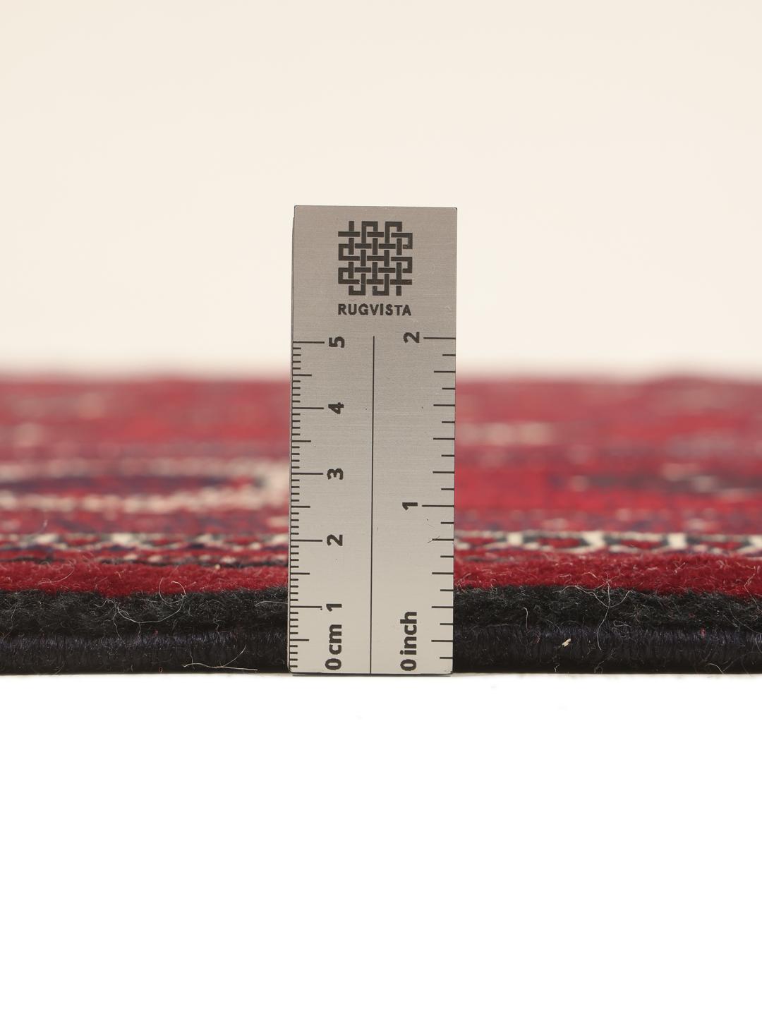 A hand-knotted Turkaman rug from the Middle East in deep red featuring traditional geometric motifs.