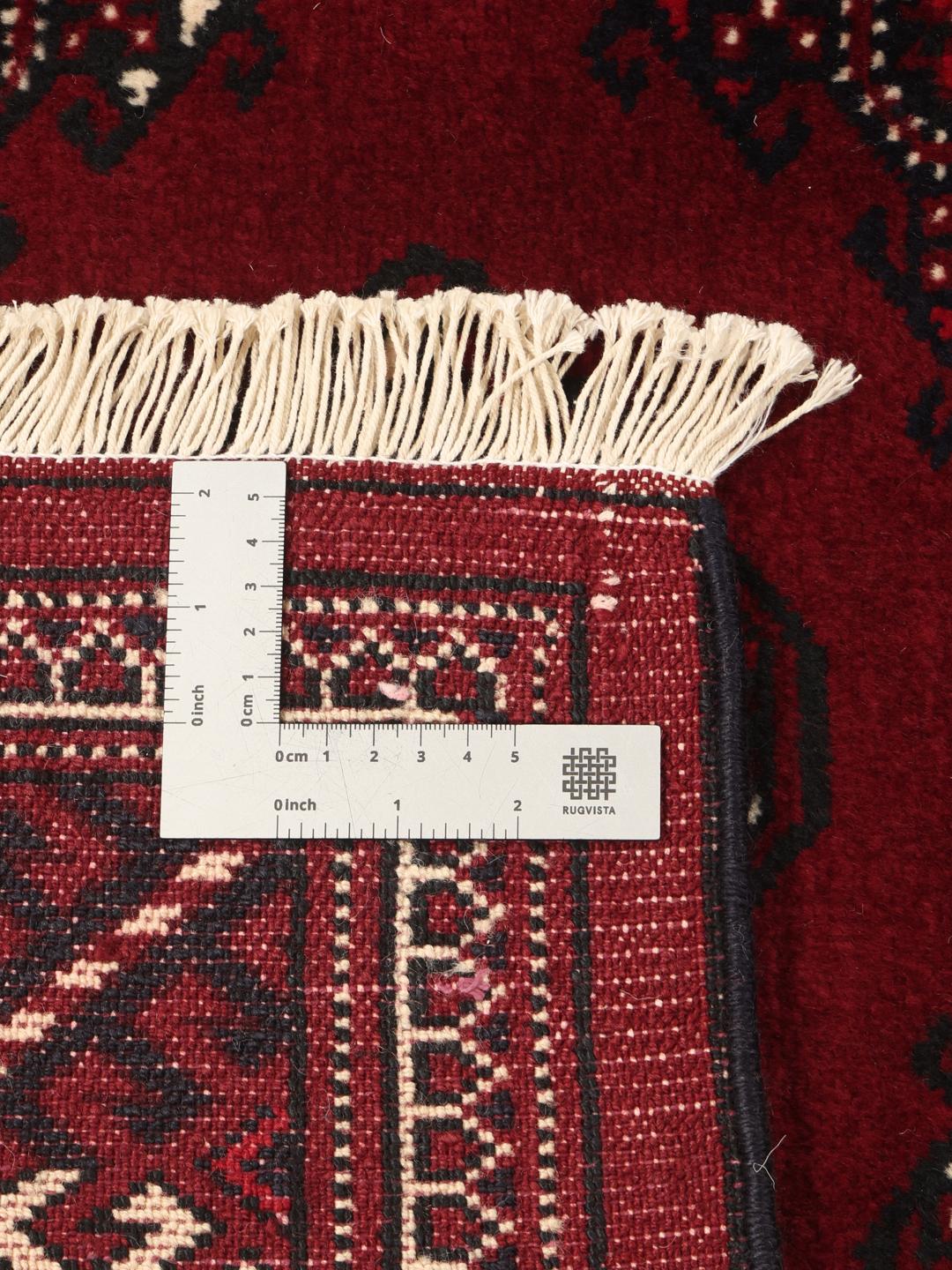 A hand-knotted Turkaman rug from the Middle East in deep red featuring traditional geometric motifs.