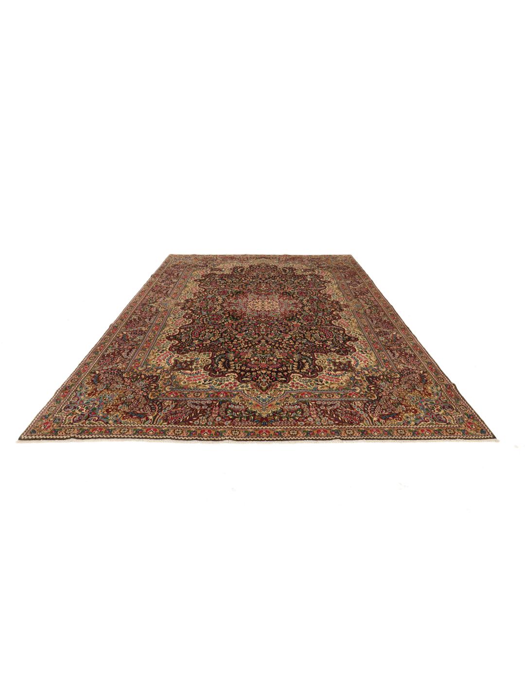 A large, rectangular Kerman rug from the Middle East featuring a complex red and dark red floral medallion pattern.