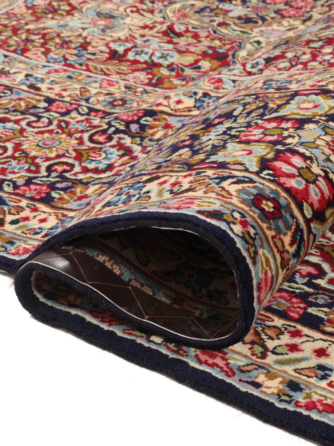 Een handgeknoopt Kerman Sherkat Farsh-tapijt met ingewikkelde florale patronen in rode en donkerblauwe tinten
