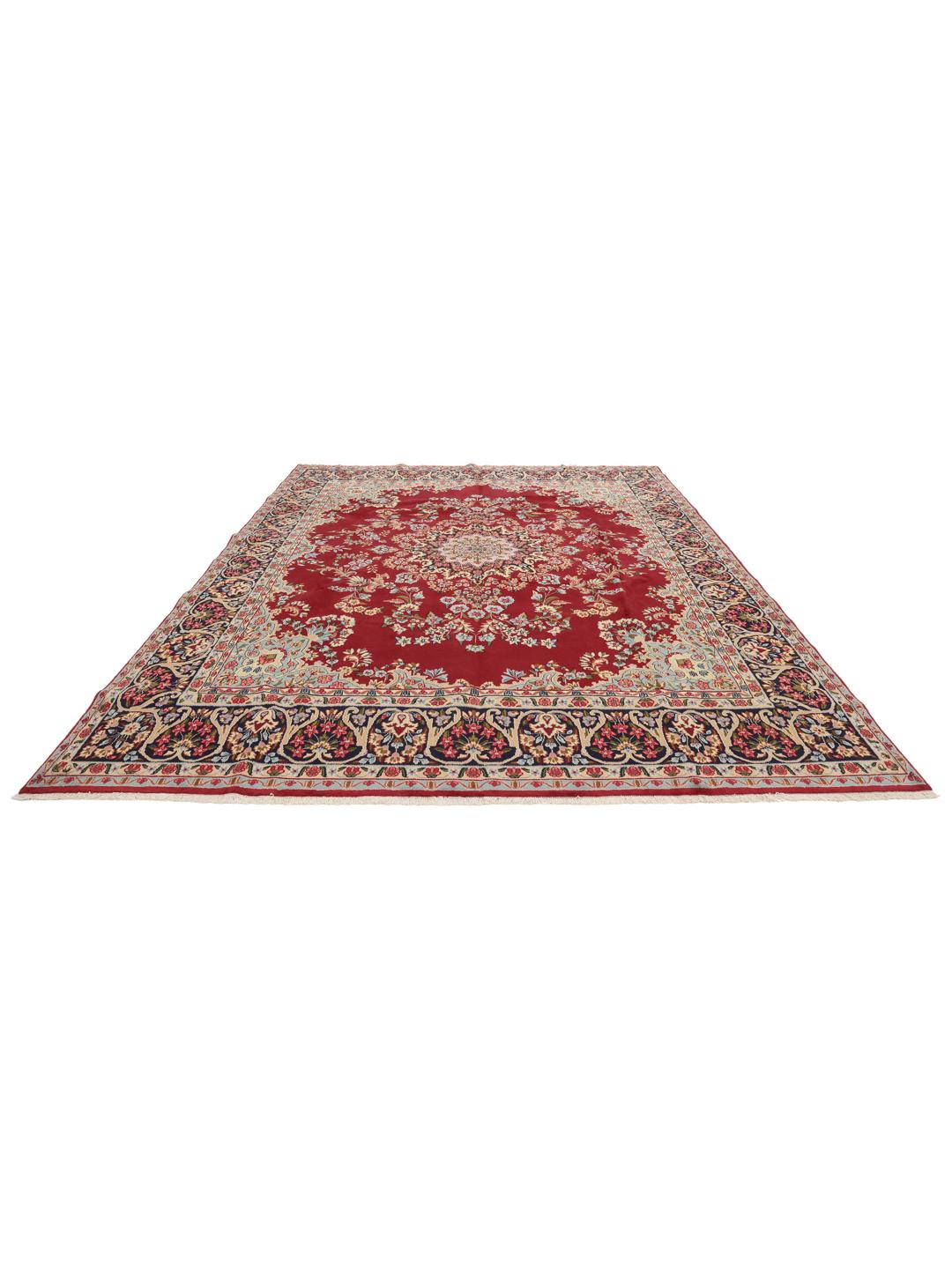 A hand-knotted Kerman rug with a large central floral medallion on a red field.
