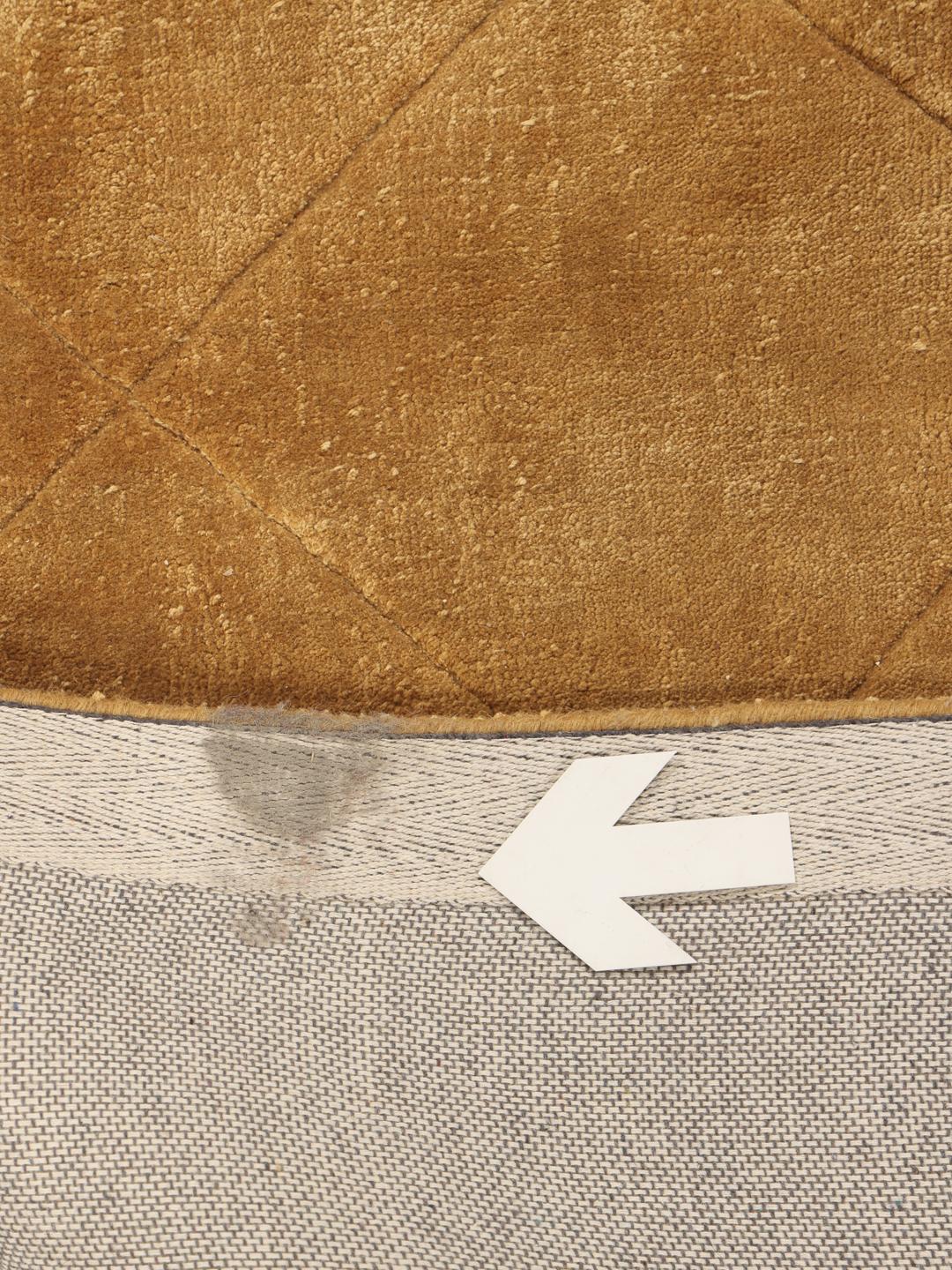 A warm brown rug with a diamond pattern