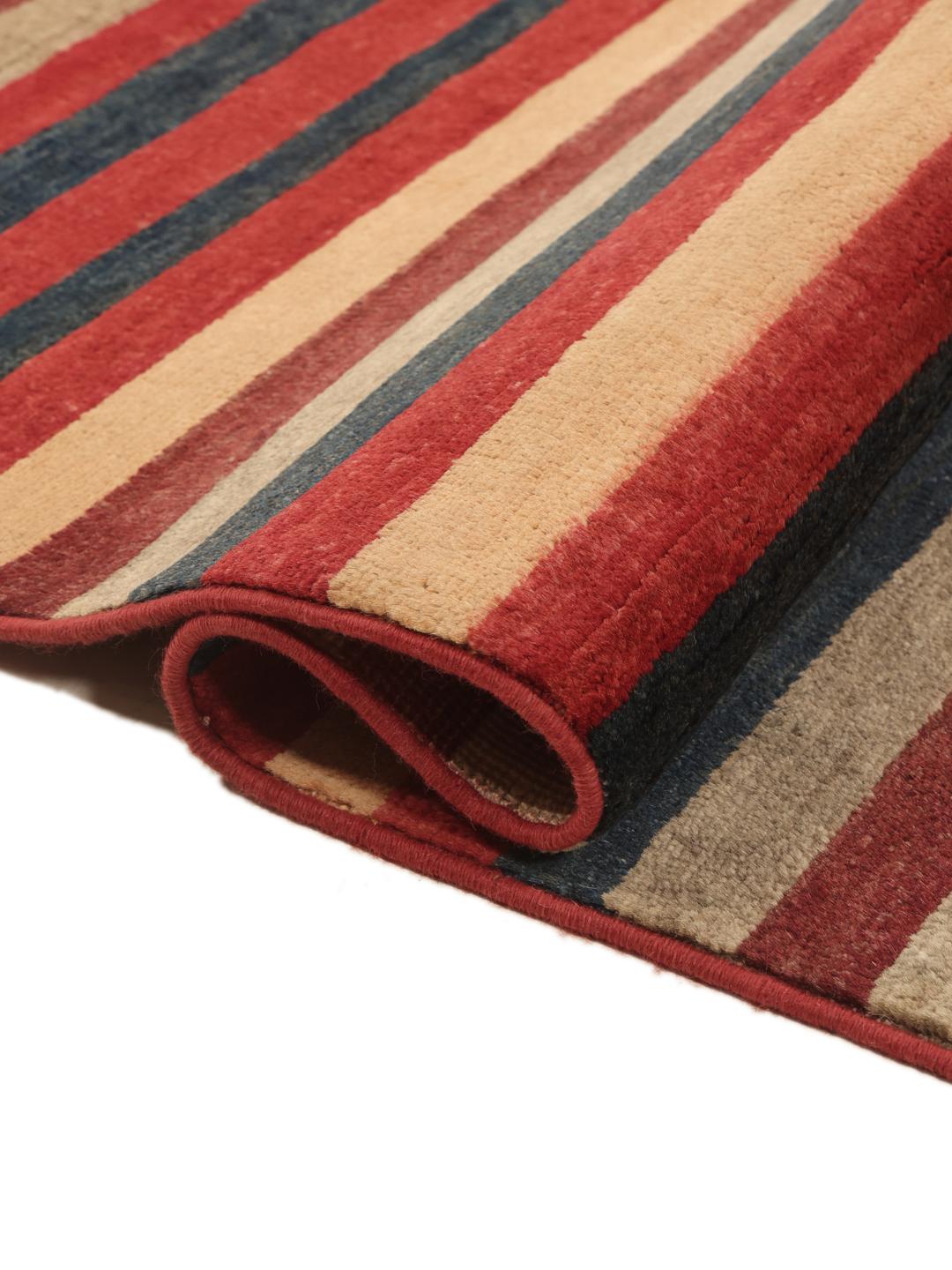 Een handgeknoopt Afghaans tapijt met horizontale strepen in rood, blauw en beige.