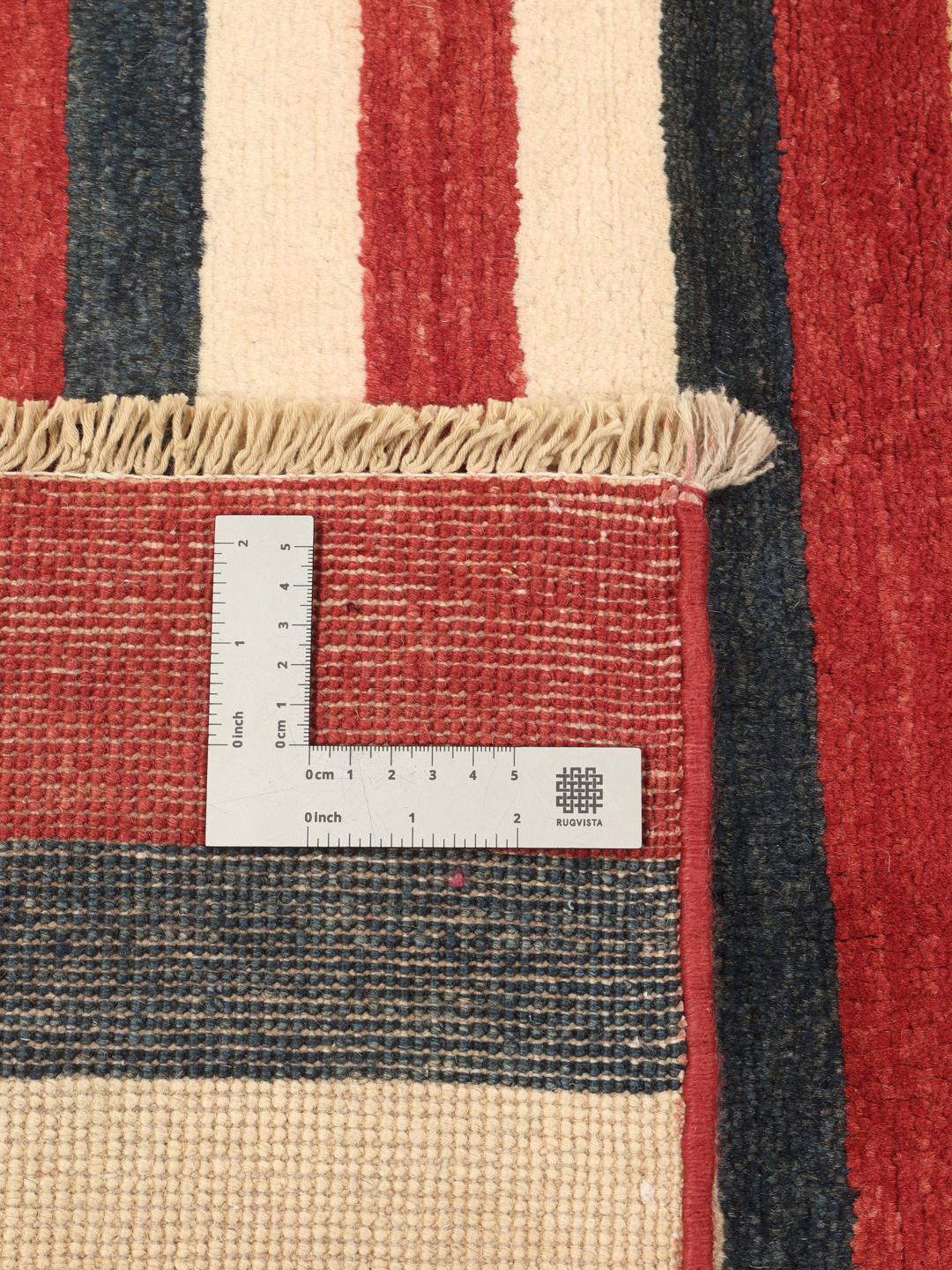 Een handgeknoopt Afghaans tapijt met horizontale strepen in rood, blauw en beige.