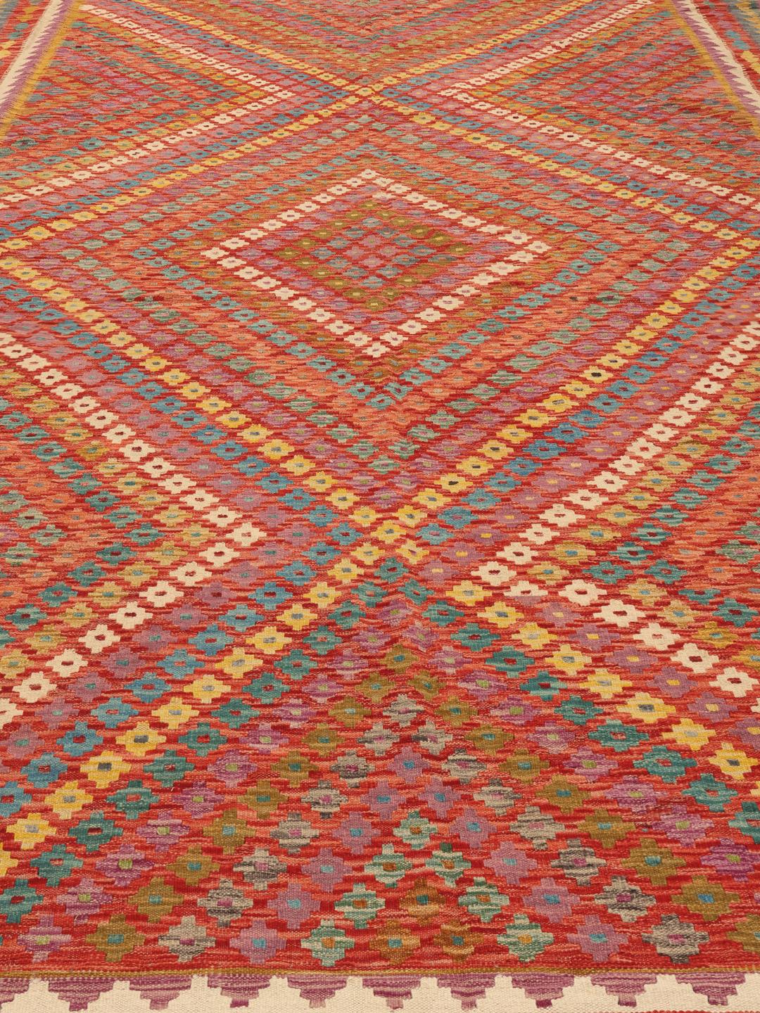Een groot handgeweven Afghan Kelim-tapijt met een levendig veelkleurig geometrisch patroon