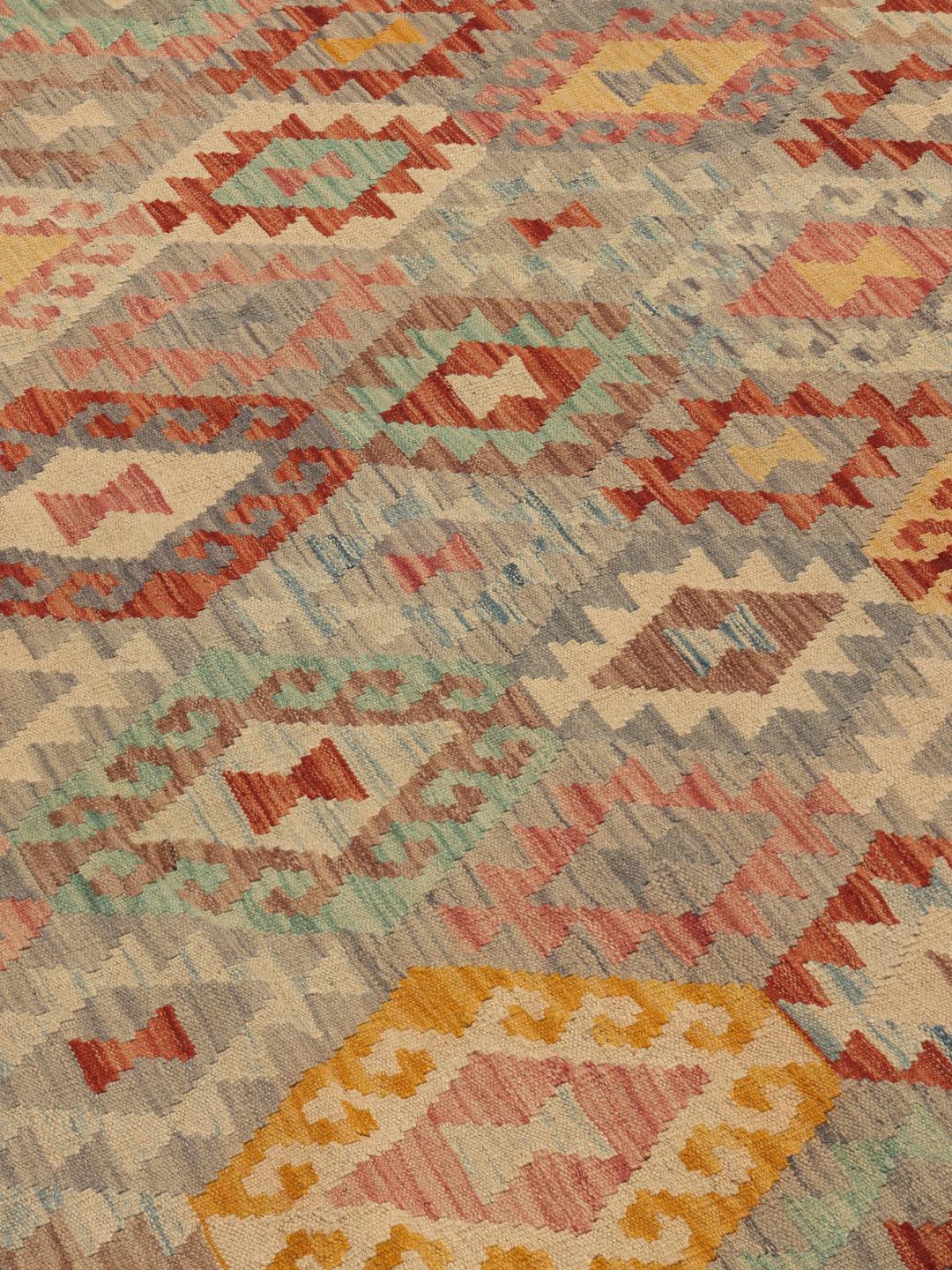 Een groot rechthoekig Afghaans Kelim-tapijt met een geometrisch diamantpatroon in meerkleurige tinten.