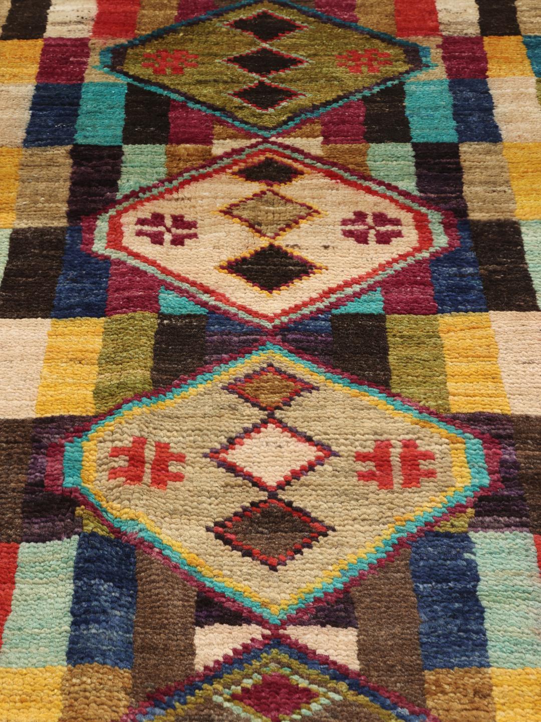 Een rechthoekig handgemaakt Berber-tapijt uit Afghanistan met een kleurrijk geometrisch patroon.