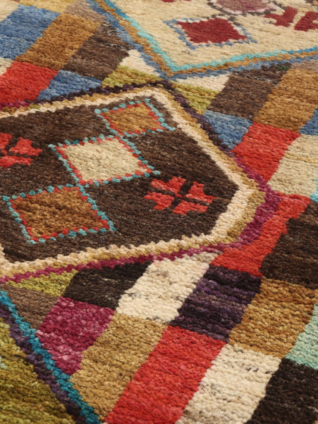 Een rechthoekig handgemaakt Berber-tapijt uit Afghanistan met een kleurrijk geometrisch patroon.