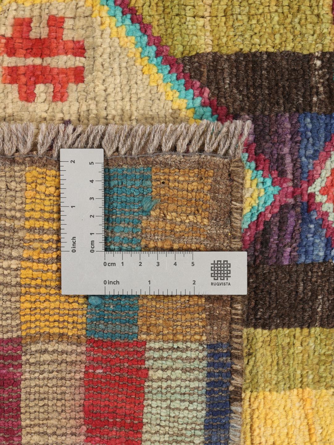 Een rechthoekig handgemaakt Berber-tapijt uit Afghanistan met een kleurrijk geometrisch patroon.