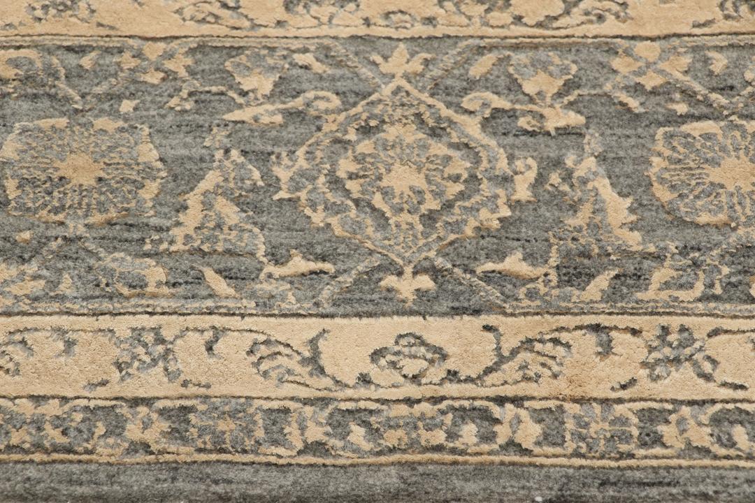 Et håndknyttet Tabriz-tæppe fra Indien med et indviklet blomstermønster i mørkegrå og beige.