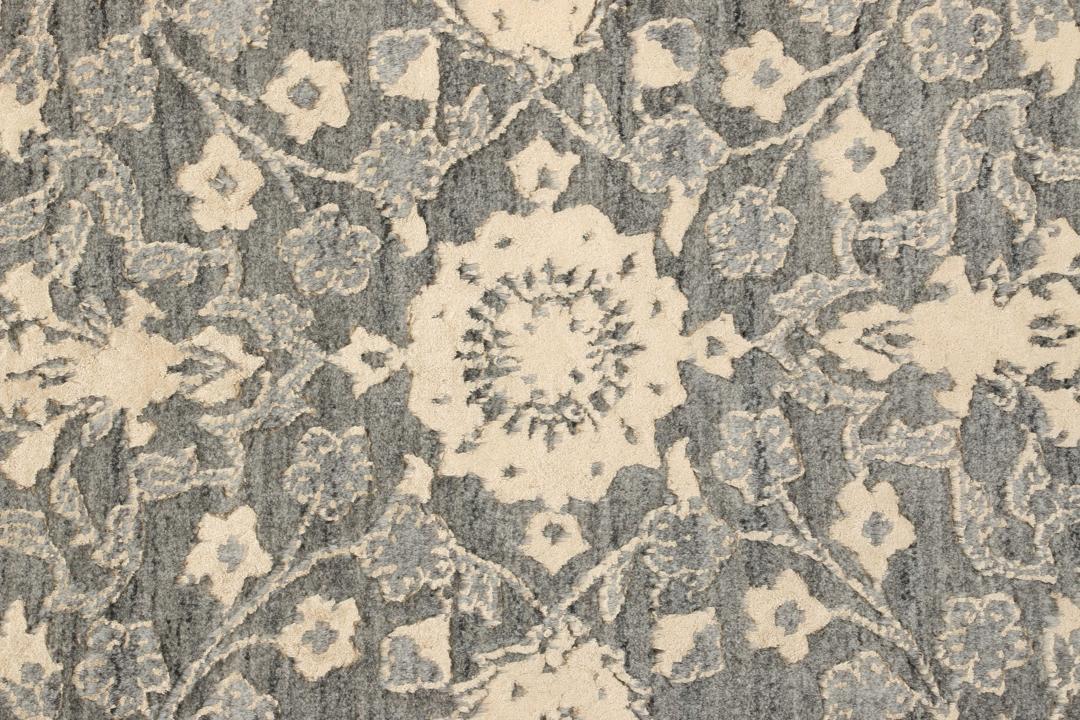 Et håndknyttet Tabriz-tæppe fra Indien med et indviklet blomstermønster i mørkegrå og beige.
