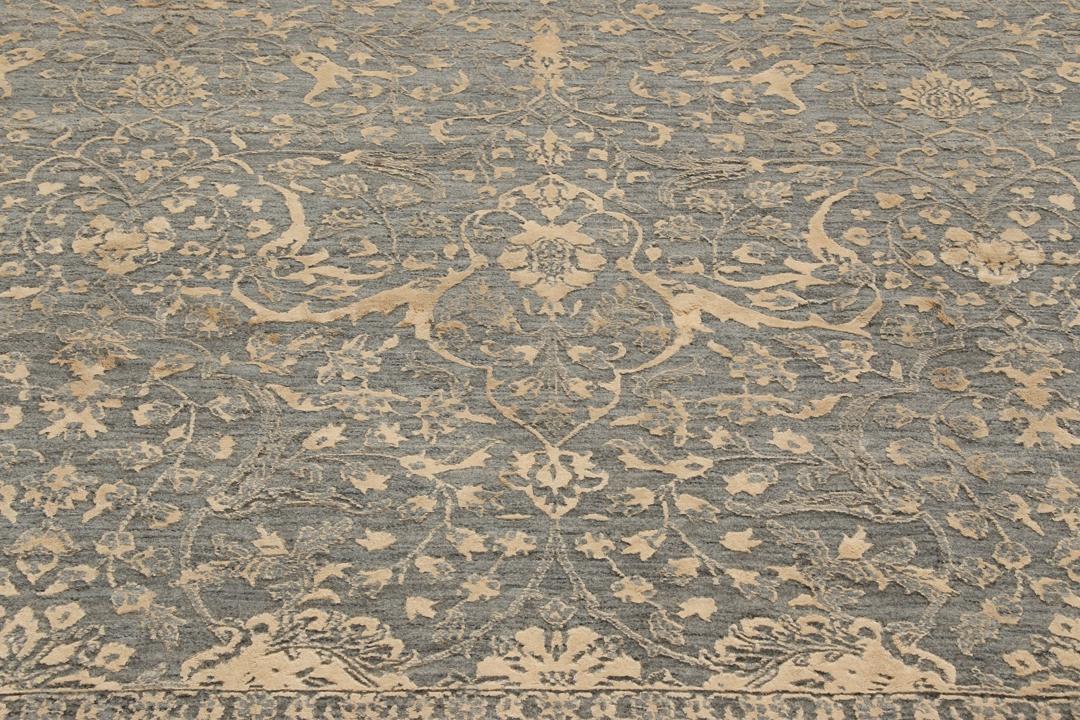 Et håndknyttet Tabriz-tæppe fra Indien med et indviklet blomstermønster i mørkegrå og beige.